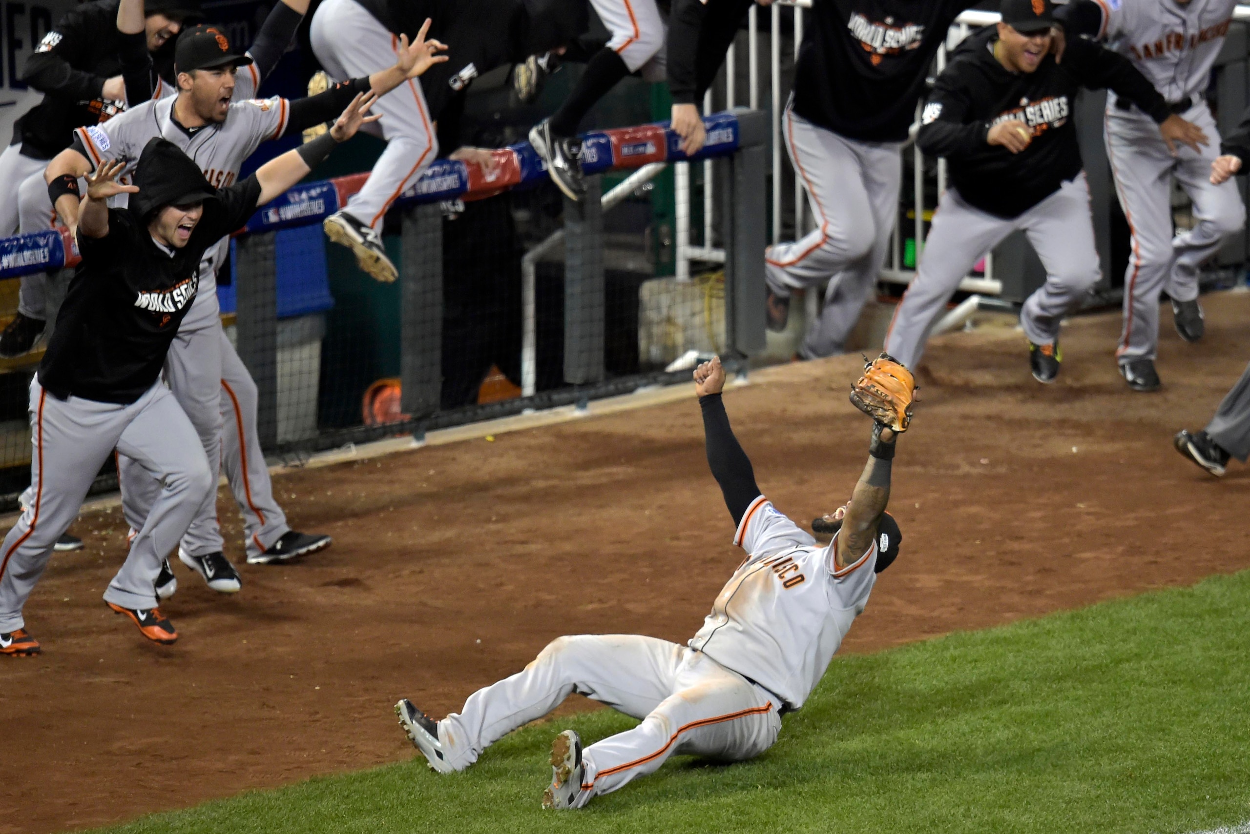 Oct 29, 2014; Kansas City, MO, USA; San Francisco Giants third baseman Pablo Sandoval (bottom) celebrates with teammates after catching a pop out for the final out of game seven of the 2014 World Series against the Kansas City Royals  at Kauffman Stadium.