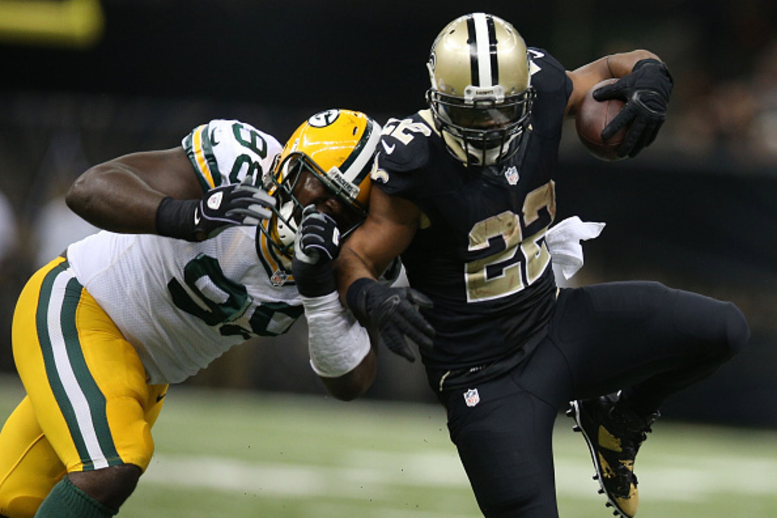 NEW ORLEANS, LA - OCTOBER 26:  Mark Ingram #22 of the New Orleans Saints runs the ball as Josh Boyd #93 of the Green Bay Packers defends during the second half at Mercedes-Benz Superdome on October 26, 2014 in New Orleans, Louisiana.  (Photo by Chris Gray