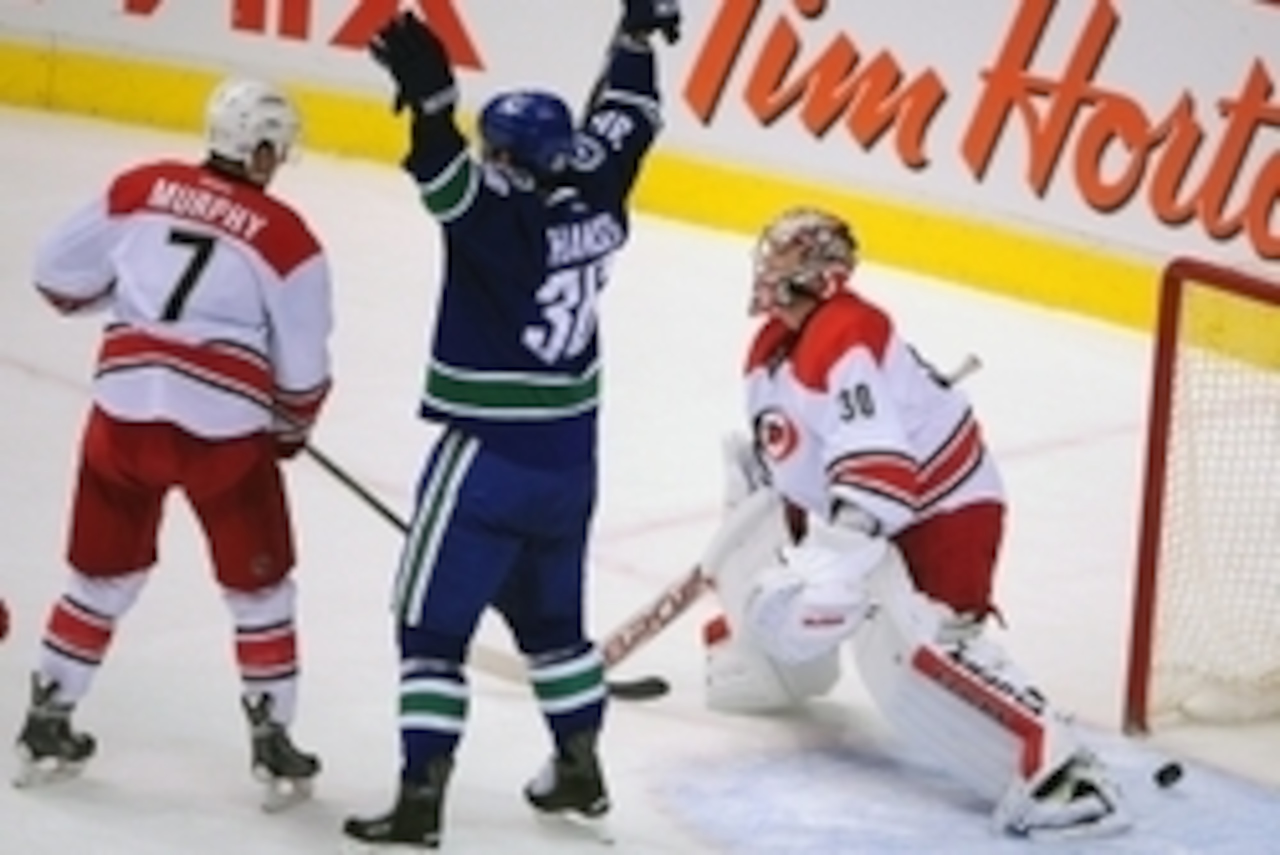 Oct 28, 2014; Vancouver, British Columbia, CAN; Vancouver Canucks forward Jannik Hansen (36) celebrates a goal scored by defenseman Luca Sbisa (not pictured) against Carolina Hurricanes goaltender Cam Ward (30) during the second period at Rogers Arena. Ma
