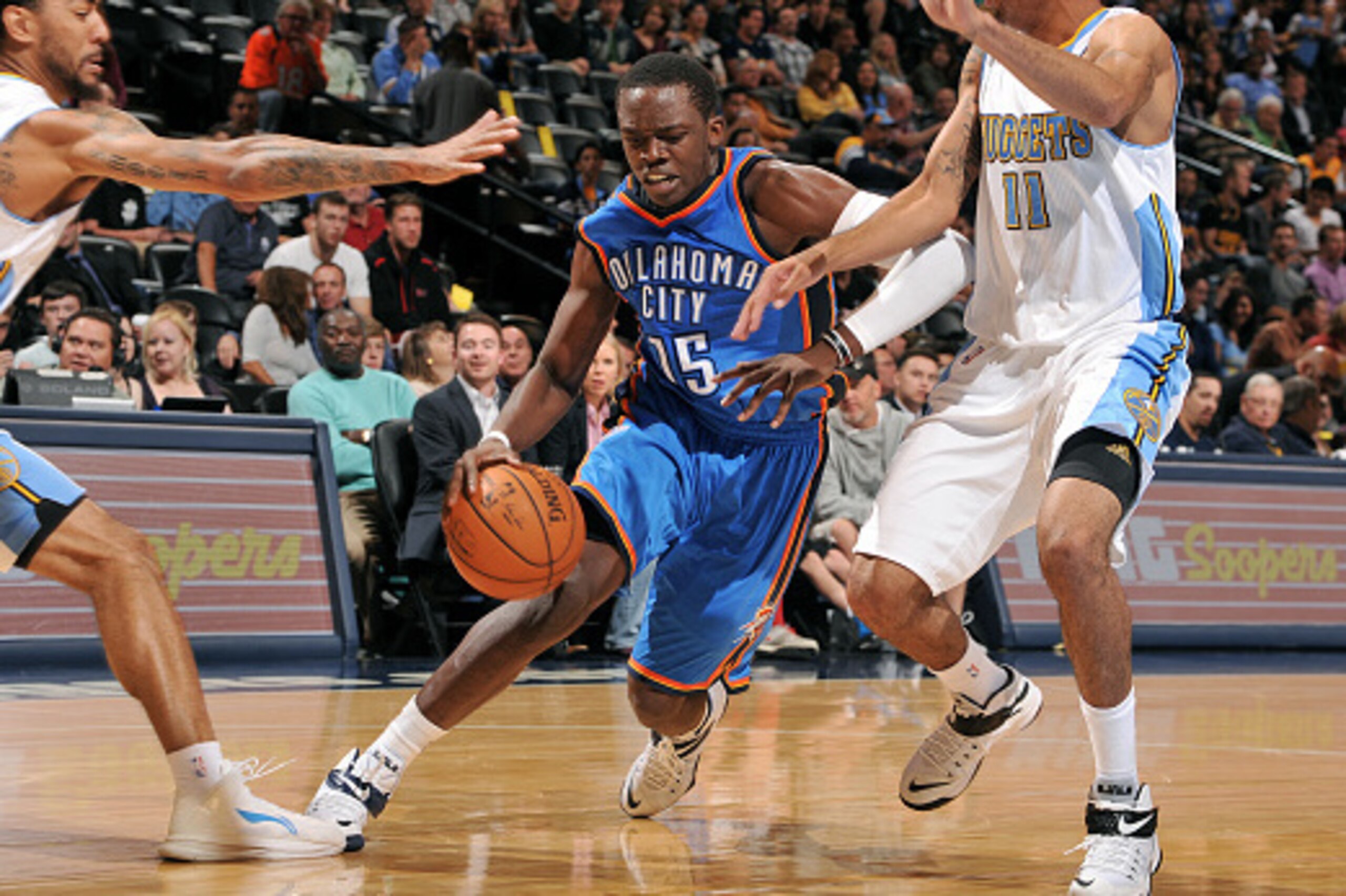 DENVER, CO - October 8: Reggie Jackson #15 of the Oklahoma City Thunder drives against Erick Green #11 of the Denver Nuggets on October 8, 2014 at the Pepsi Center in Denver, Colorado. NOTE TO USER: User expressly acknowledges and agrees that, by download