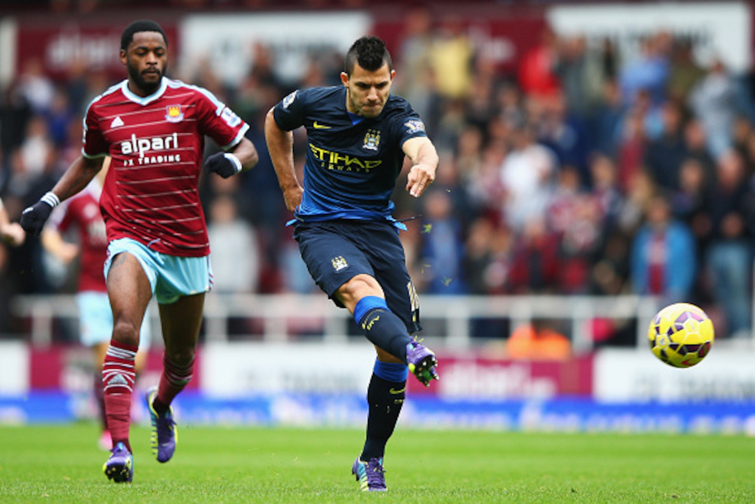 LONDON, ENGLAND - OCTOBER 25:  Sergio Aguero of Manchester City shoots watched by Alexandre Song of West Ham United during the Barclays Premier League match between West Ham United and Manchester City at Boleyn Ground on October 25, 2014 in London, Englan