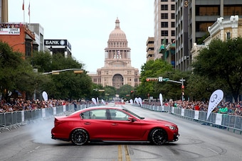 AUSTIN, TX - OCTOBER 29:  Sebastian Vettel of Germany and Infiniti Red Bull Racing drives an Infiniti Q50 Eau Rouge along North Congress Avenue backdropped by the Texas Capitol building during previews ahead of the United States Formula One Grand Prix on 