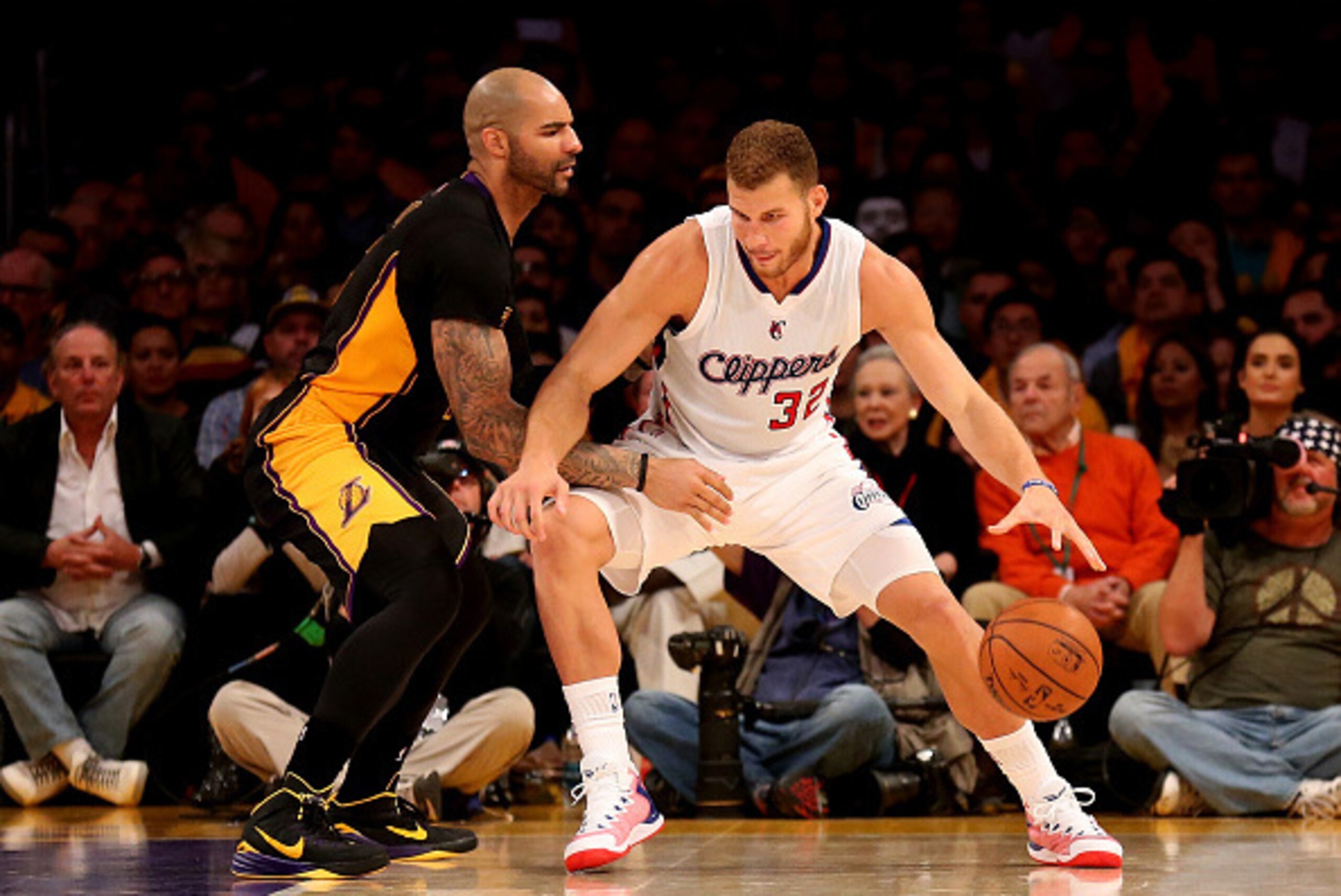 LOS ANGELES, CA - OCTOBER 31: Blake Griffin #32 of the Los Angeles Clippers drives against Carlos Boozer #5 of the Los Angeles Lakers at Staples Center on October 31, 2014 in Los Angeles, California. The Clippers won 118-111.  NOTE TO USER: User expressly