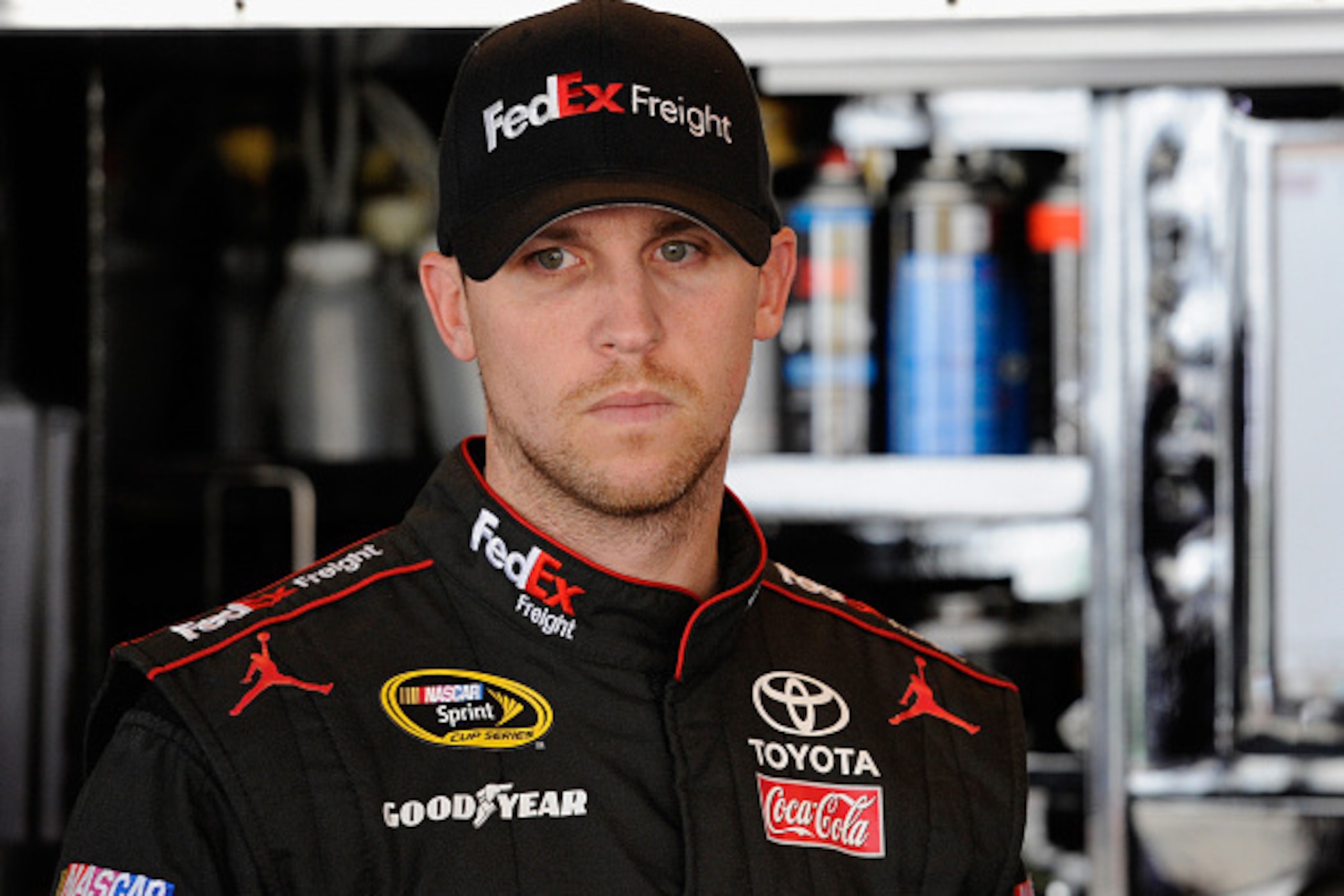 DOVER, DE - SEPTEMBER 27:  Denny Hamlin, driver of the #11 FedEx Freight Toyota, stands in the garage area during practice for the NASCAR Sprint Cup Series AAA 400 at Dover International Speedway on September 27, 2014 in Dover, Delaware.  (Photo by Jared 