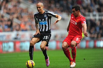 NEWCASTLE UPON TYNE, ENGLAND - NOVEMBER 01:  Newcastle player Gabriel Obertan (L) pulls up with an injury as Dejan Lovren looks on during the Barclays Premier League match between Newcastle United and Liverpool at St James' Park on November 1, 2014 in New