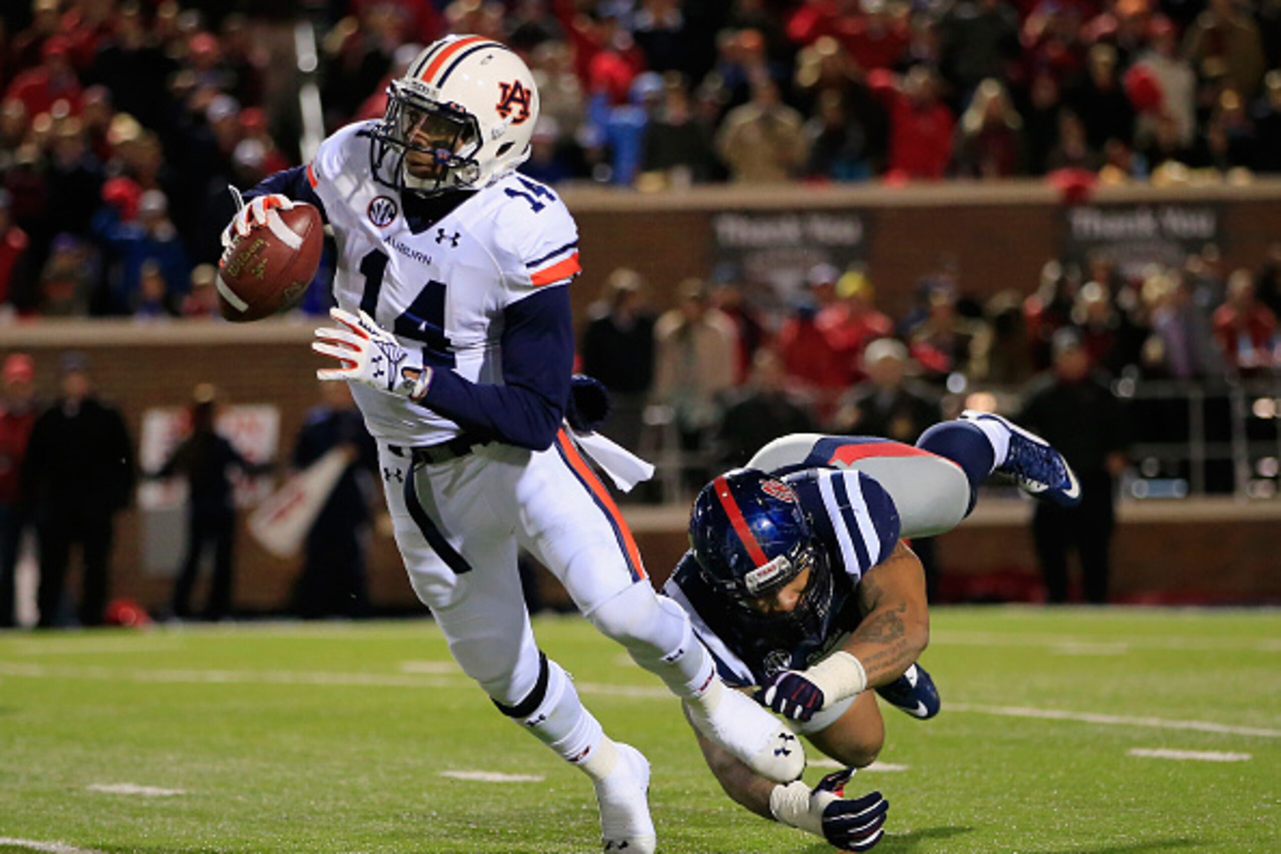 OXFORD, MS - NOVEMBER 01:  Quarterback Nick Marshall #14 of the Auburn Tigers eludes Robert Nkemdiche #5 of the Mississippi Rebels and completes a first down pass in the third quarter at Vaught-Hemingway Stadium on November 1, 2014 in Oxford, Mississippi.