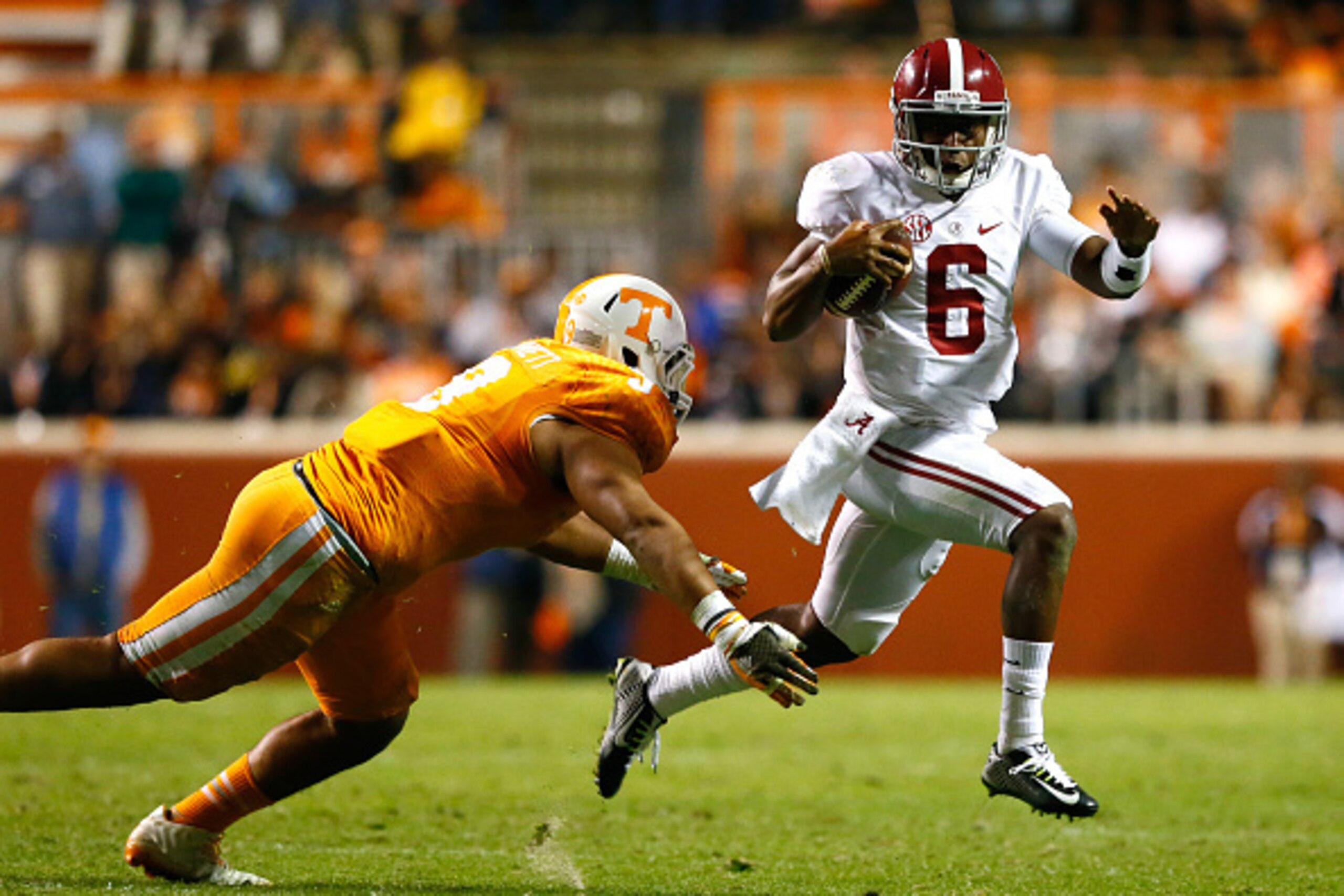 KNOXVILLE, TN - OCTOBER 25:  Blake Sims #6 of the Alabama Crimson Tide rushes away from Derek Barnett #9 of the Tennessee Volunteers at Neyland Stadium on October 25, 2014 in Knoxville, Tennessee.  (Photo by Kevin C. Cox/Getty Images)