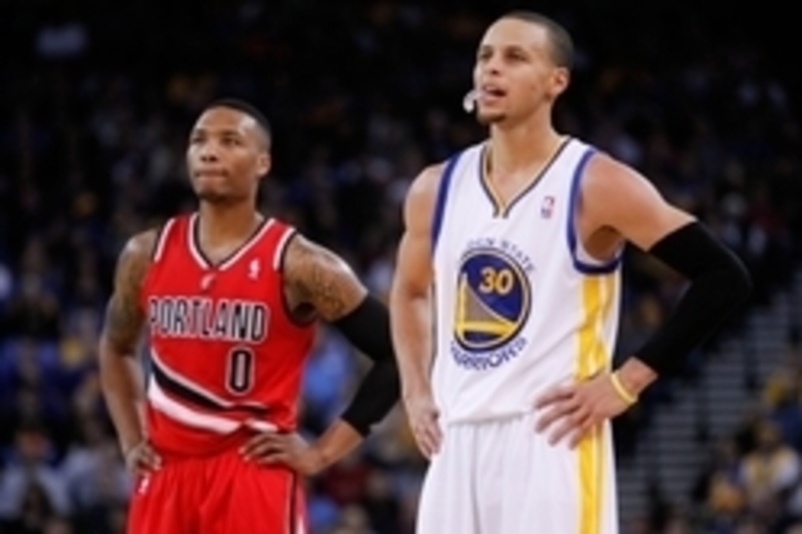 Jan 26, 2014; Oakland, CA, USA; Golden State Warriors guard Stephen Curry (30) stands next to Portland Trail Blazers guard Damian Lillard (0) in the second quarter at Oracle Arena. Mandatory Credit: Cary Edmondson-USA TODAY Sports