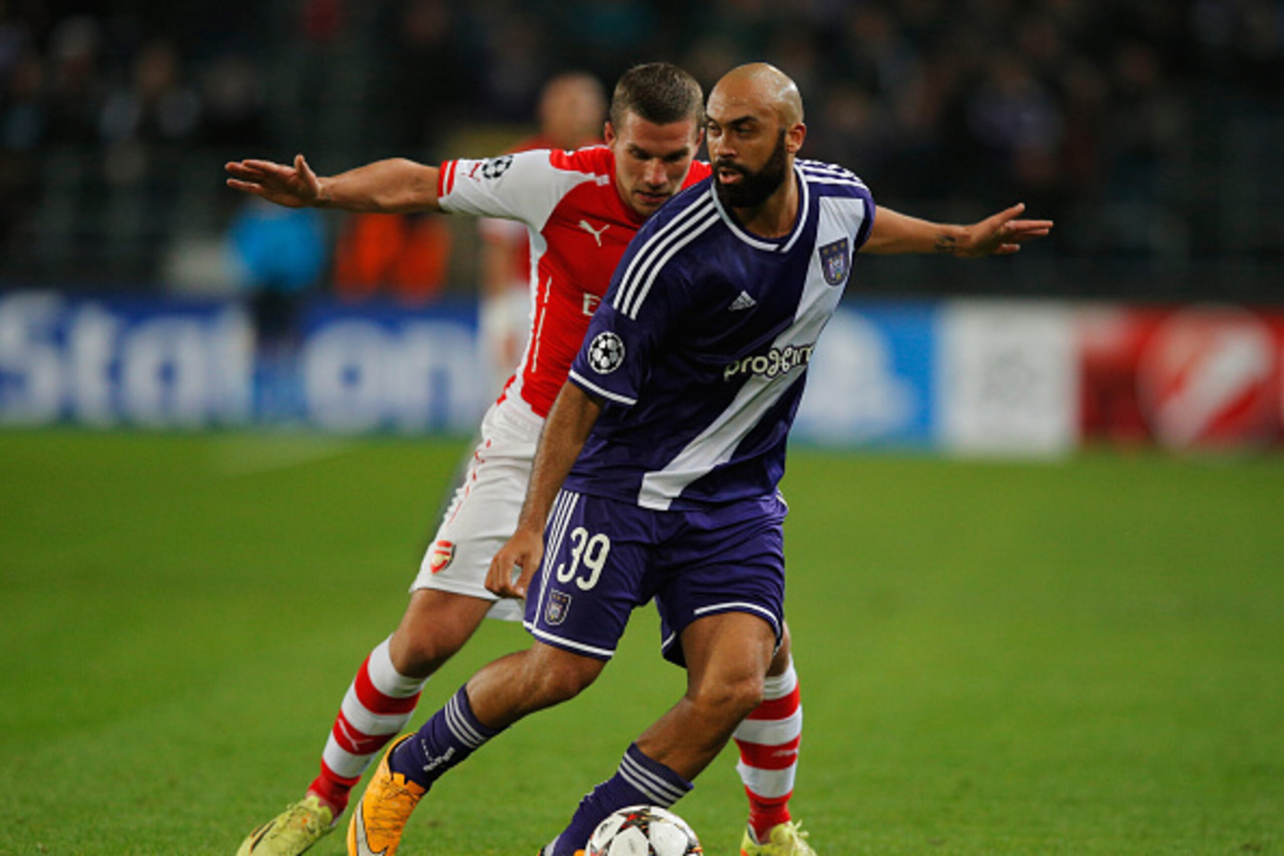 BRUSSELS, BELGIUM - OCTOBER 22:  Anthony Vanden Borre of Anderlecht holds off Lukas Podolski of Arsenal during the UEFA Champions League Group D match between RSC Anderlecht and Arsenal at Constant Vanden Stock Stadium on October 22, 2014 in Brussels, Bel