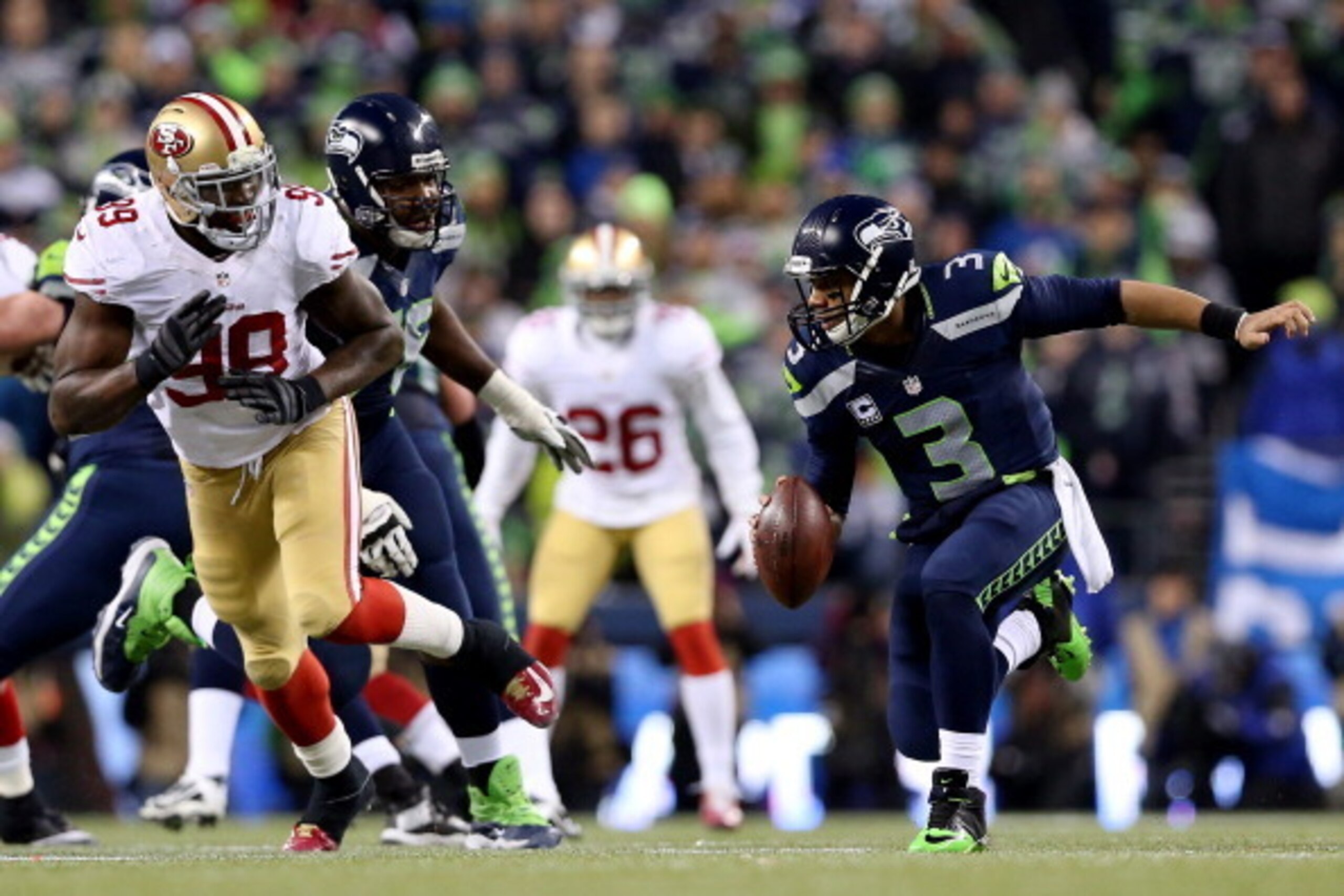 SEATTLE, WA - JANUARY 19:  Quarterback Russell Wilson #3 of the Seattle Seahawks is pressured by outside linebacker Aldon Smith #99 of the San Francisco 49ers during the 2014 NFC Championship at CenturyLink Field on January 19, 2014 in Seattle, Washington