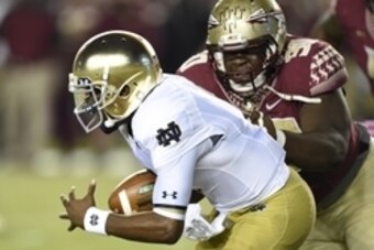 Oct 18, 2014; Tallahassee, FL, USA;  Notre Dame Fighting Irish quarterback Everett Golson (5) tries to avoid the sack from Florida State Seminoles defensive tackle Eddie Goldman (90) during the first quarter at Doak Campbell Stadium. Mandatory Credit: Joh
