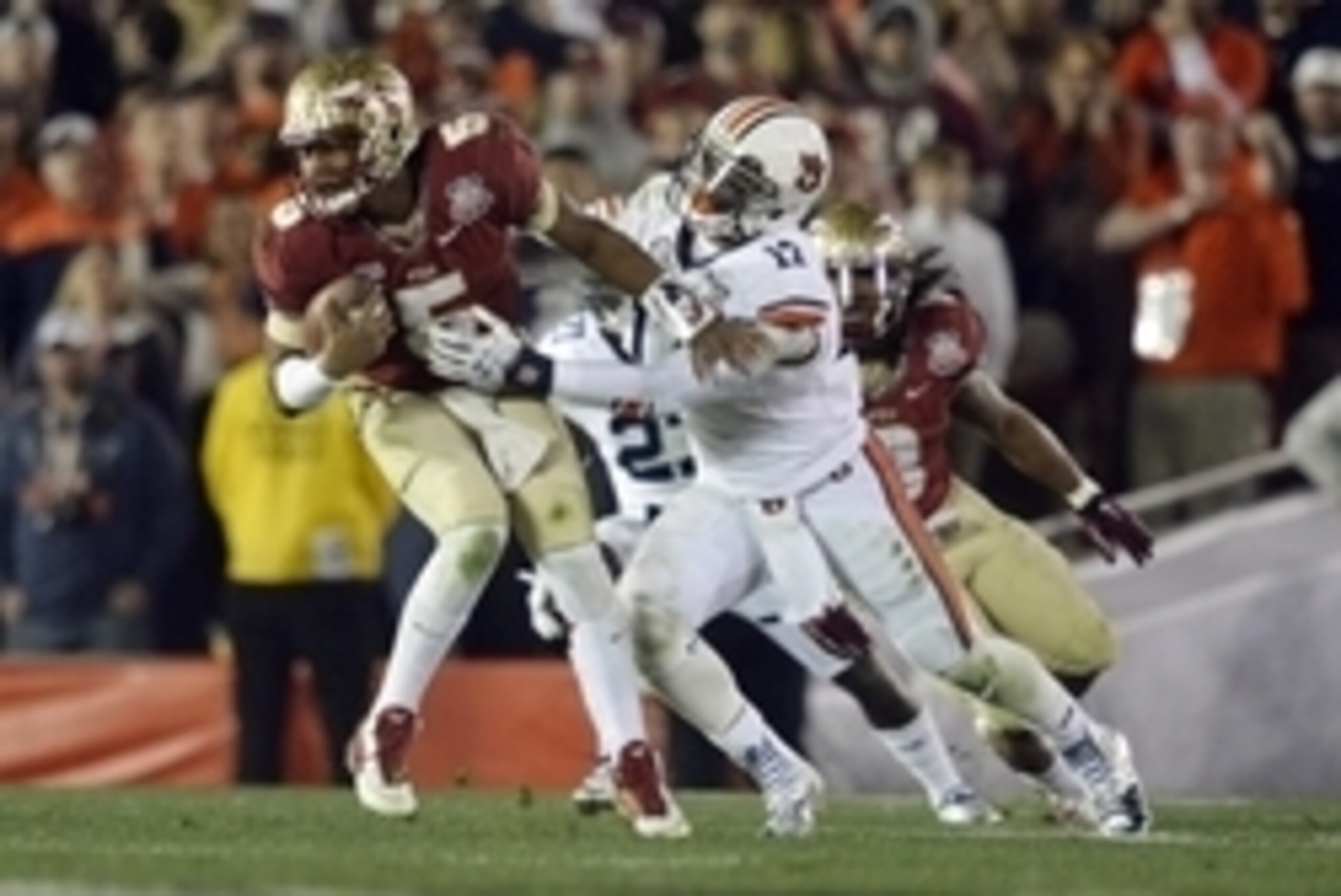 Jan 6, 2014; Pasadena, CA, USA; Florida State Seminoles quarterback Jameis Winston (5) is tackled by Auburn Tigers linebacker Kris Frost (17) during the second half of the 2014 BCS National Championship game at the Rose Bowl.  Mandatory Credit: Robert Han