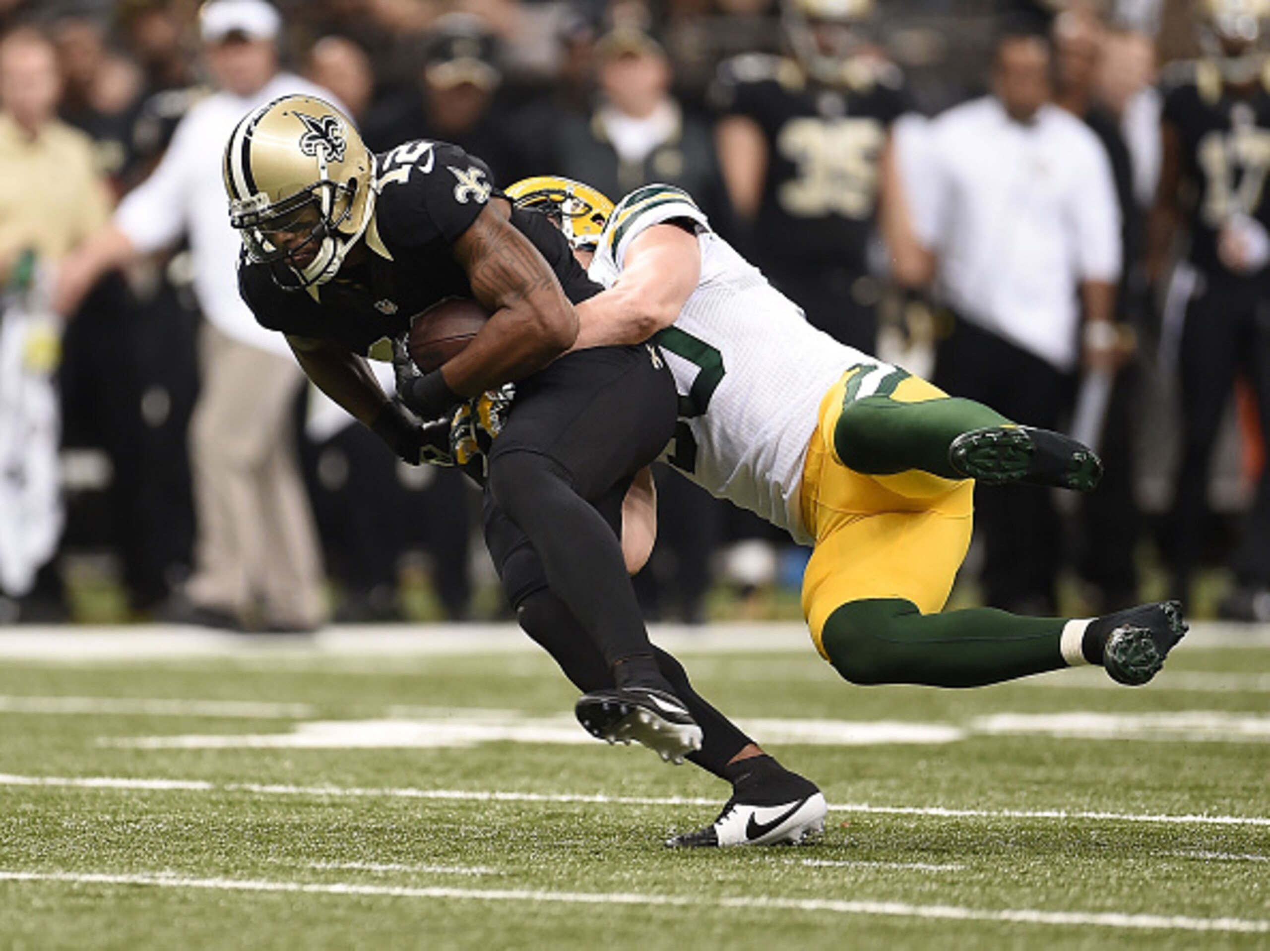 NEW ORLEANS, LA - OCTOBER 26: Marques Colston #12 of the New Orleans Saints runs the ball as A.J. Hawk #50 of the Green Bay Packers tackles him during the first quarter at Mercedes-Benz Superdome on October 26, 2014 in New Orleans, Louisiana. (Photo by St