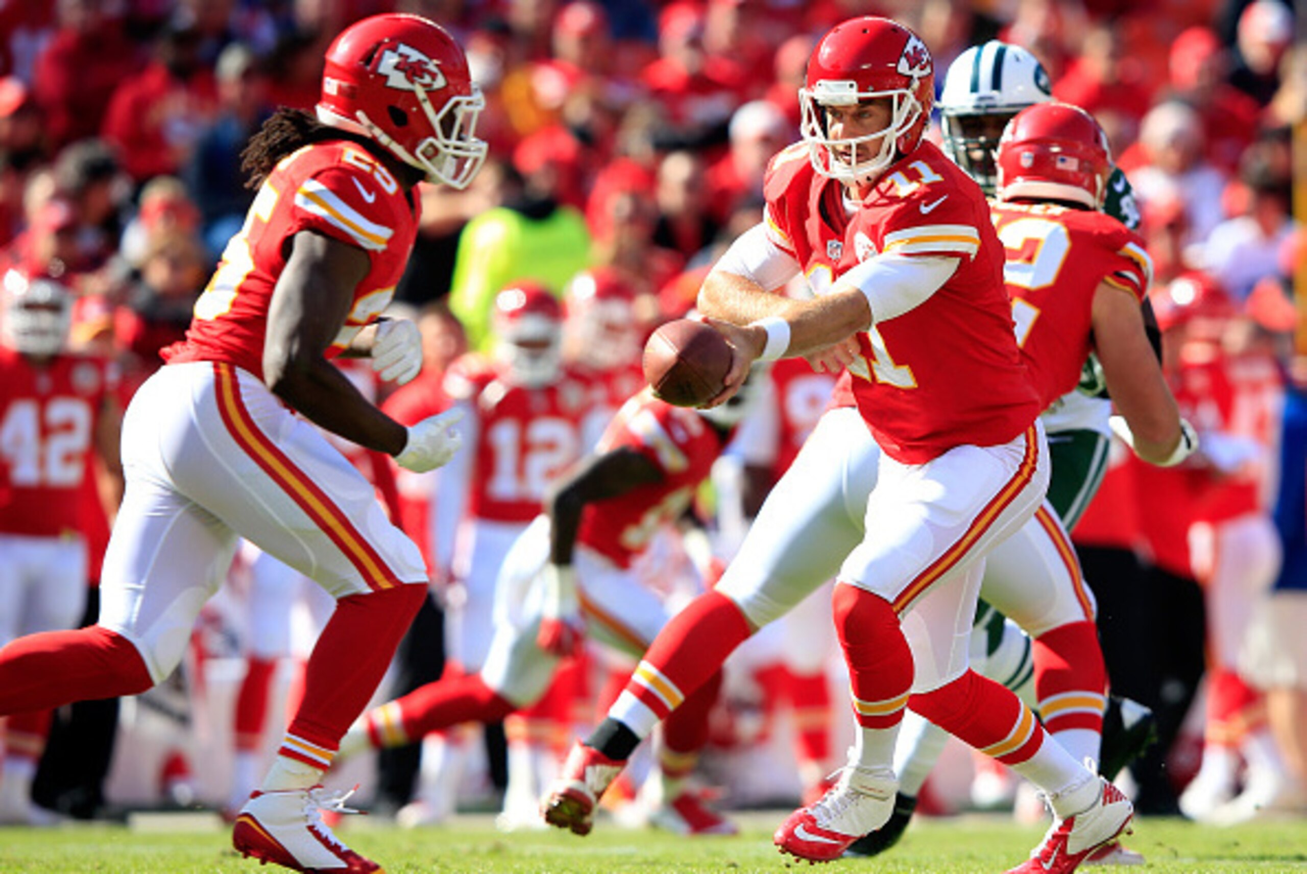KANSAS CITY, MO - NOVEMBER 02:   Alex Smith #11 of the Kansas City Chiefs drops back to  Jamaal Charles #25 for a run play against the New York Jets during the first quarter at Arrowhead Stadium on November 2, 2014 in Kansas City, Missouri.  (Photo by Jam