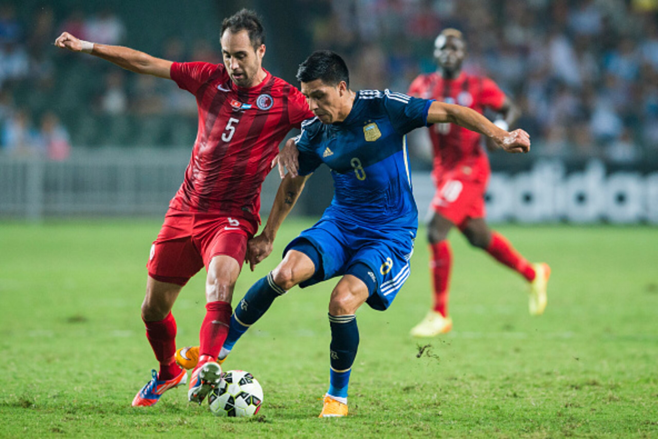 HONG KONG - OCTOBER 14: Enzo Perez (R) of Argentina and Andy Hannes of Hong Kong in action during the International Friendly Match between Hong Kong and Argentina at the Hong Kong Stadium on October 14, 2014 in Hong Kong, Hong Kong. (Photo by Victor Fra HONG KONG - OCTOBER 14: Enzo Perez (R) of Argentina and Andy Hannes of Hong Kong in action during the International Friendly Match between Hong Kong and Argentina at the Hong Kong Stadium on October 14, 2014 in Hong Kong, Hong Kong. (Photo by Victor Fra