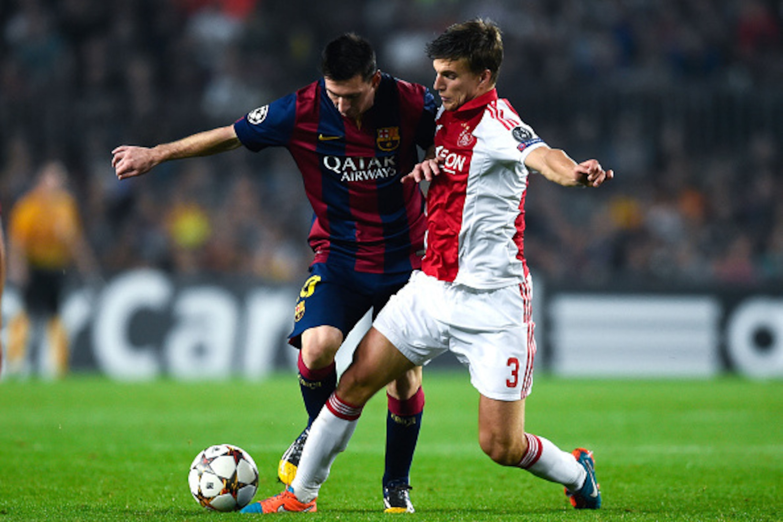 BARCELONA, SPAIN - OCTOBER 21:  Lionel Messi of FC Barcelona competes for the ball with Joel Veltman of AFC Ajax during a UEFA Champions League Group F match between FC Barcelona and AFC Ajax at the Camp Nou Stadium on October 21, 2014 in Barcelona, Spain