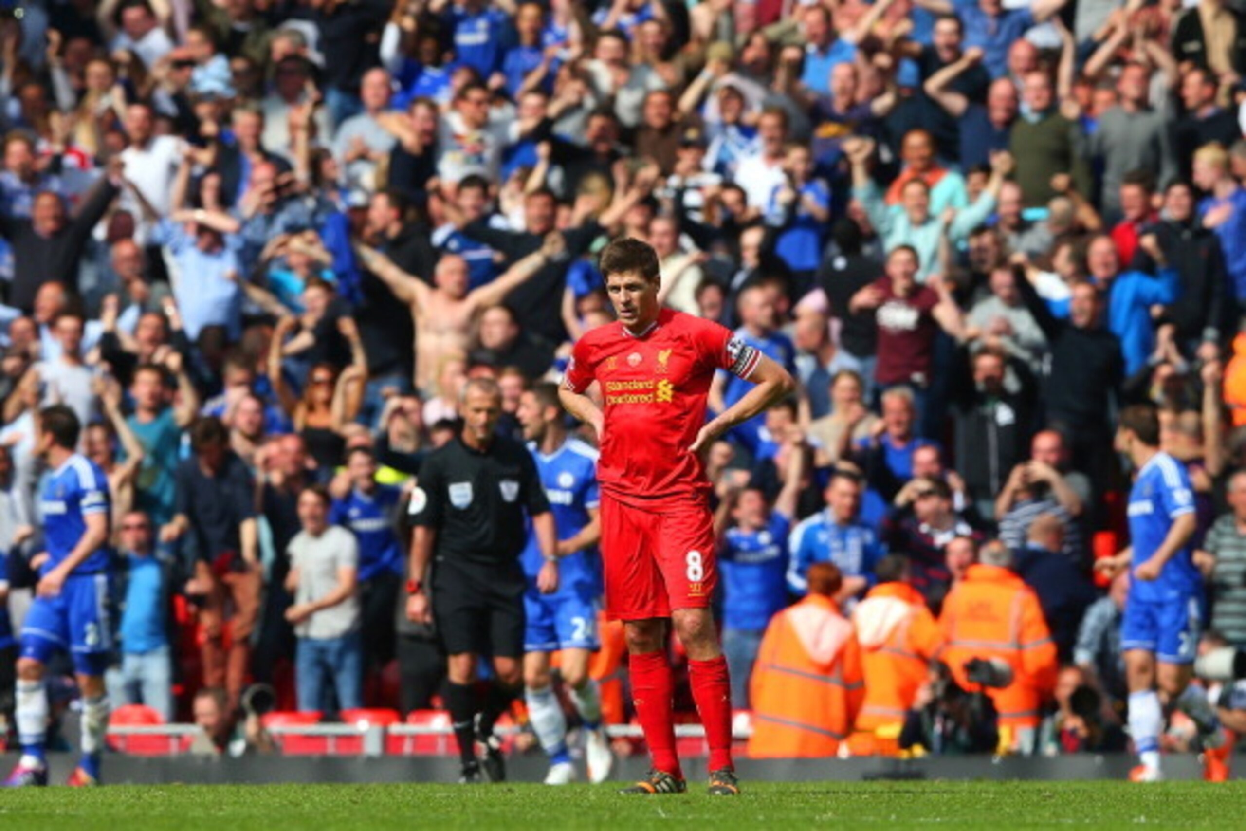 LIVERPOOL, ENGLAND - APRIL 27: (EDITORS NOTE: Retransmission of image 487064815 with alternate crop.) A dejected Steven Gerrard of Liverpool looks on as the Chelsea fans celebrate after Willian of Chelsea scored their second goal during the Barclays Premi
