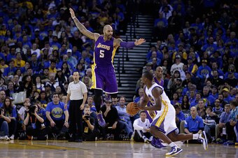 OAKLAND, CA - NOVEMBER 01:  Carlos Boozer #5 of the Los Angeles Lakers jumps in the air to try to defend Harrison Barnes #40 of the Golden State Warriors at ORACLE Arena on November 1, 2014 in Oakland, California. NOTE TO USER: User expressly acknowledges
