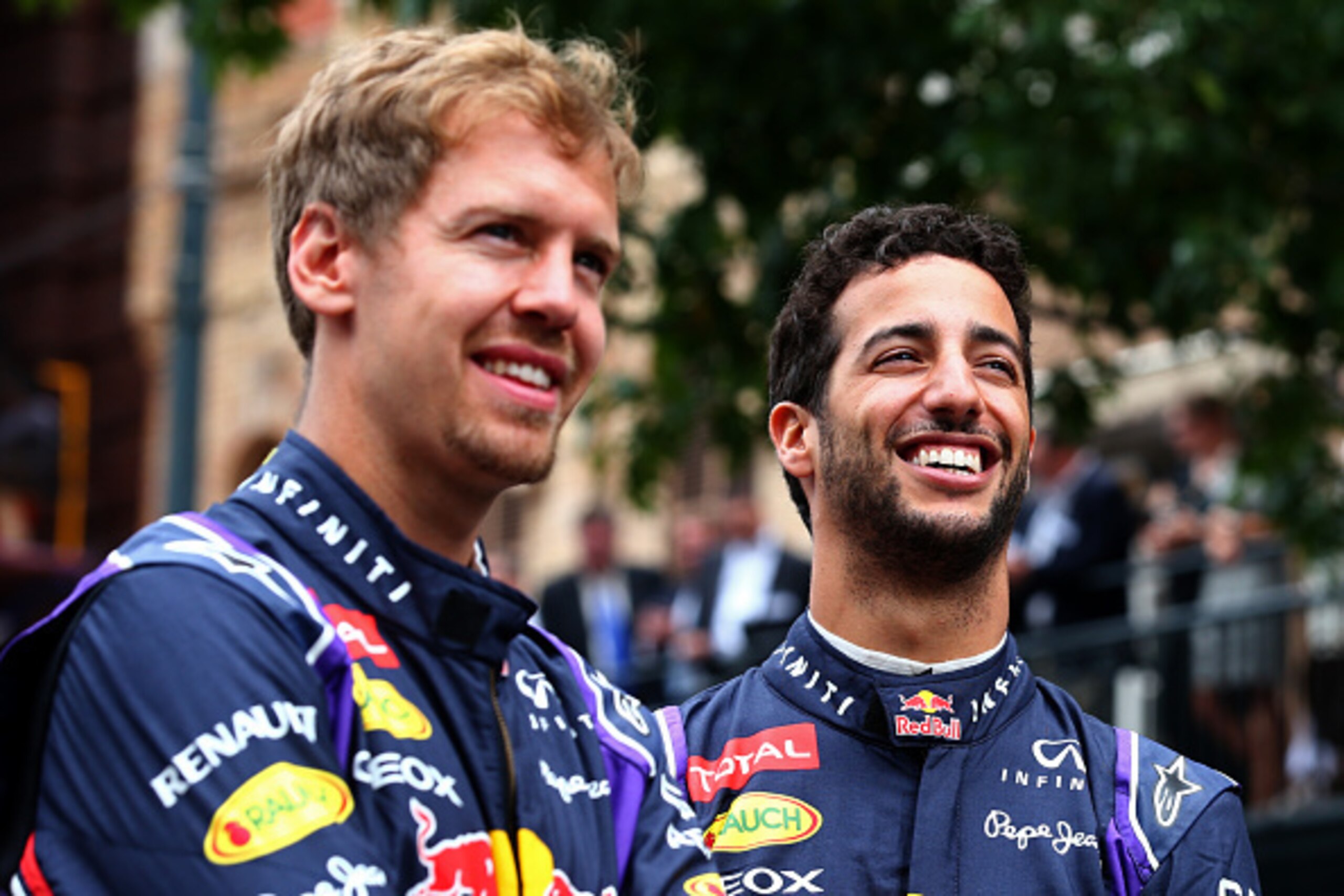 AUSTIN, TX - OCTOBER 29:  Daniel Ricciardo of Australia and Infiniti Red Bull Racing and Sebastian Vettel of Germany and Infiniti Red Bull Racing smile as they talk before driving along North Congress Avenue during previews ahead of the United States Form