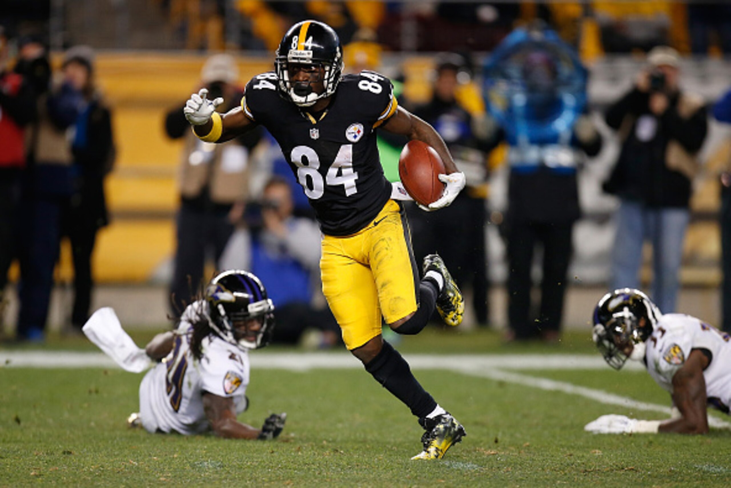 PITTSBURGH, PA - NOVEMBER 02:  Antonio Brown #84 of the Pittsburgh Steelers avoids a tackle by Lardarius Webb #21 and Will Hill #33 of the Baltimore Ravens and scores a 54 yard touchdown during the fourth quarter at Heinz Field on November 2, 2014 in Pitt