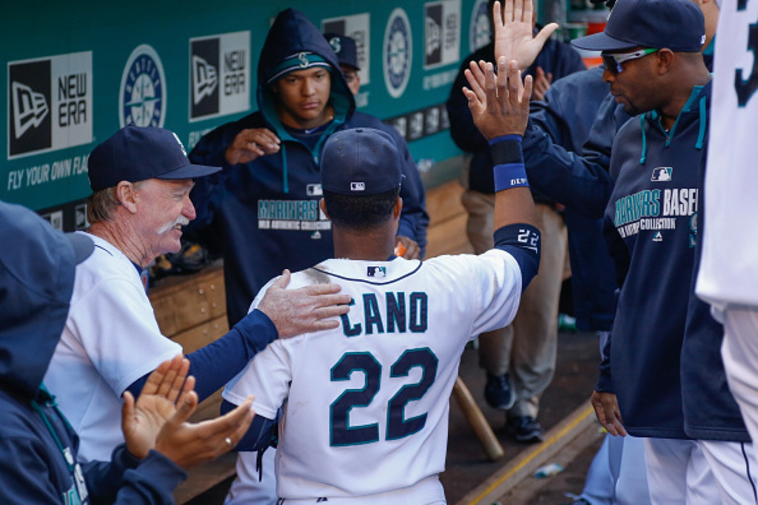 SEATTLE, WA - SEPTEMBER 28:  Robinson Cano #22 of the Seattle Mariners is congratulated by teammates after being removed from the game against the Los Angeles Angels of Anaheim at Safeco Field on September 28, 2014 in Seattle, Washington. The Mariners def