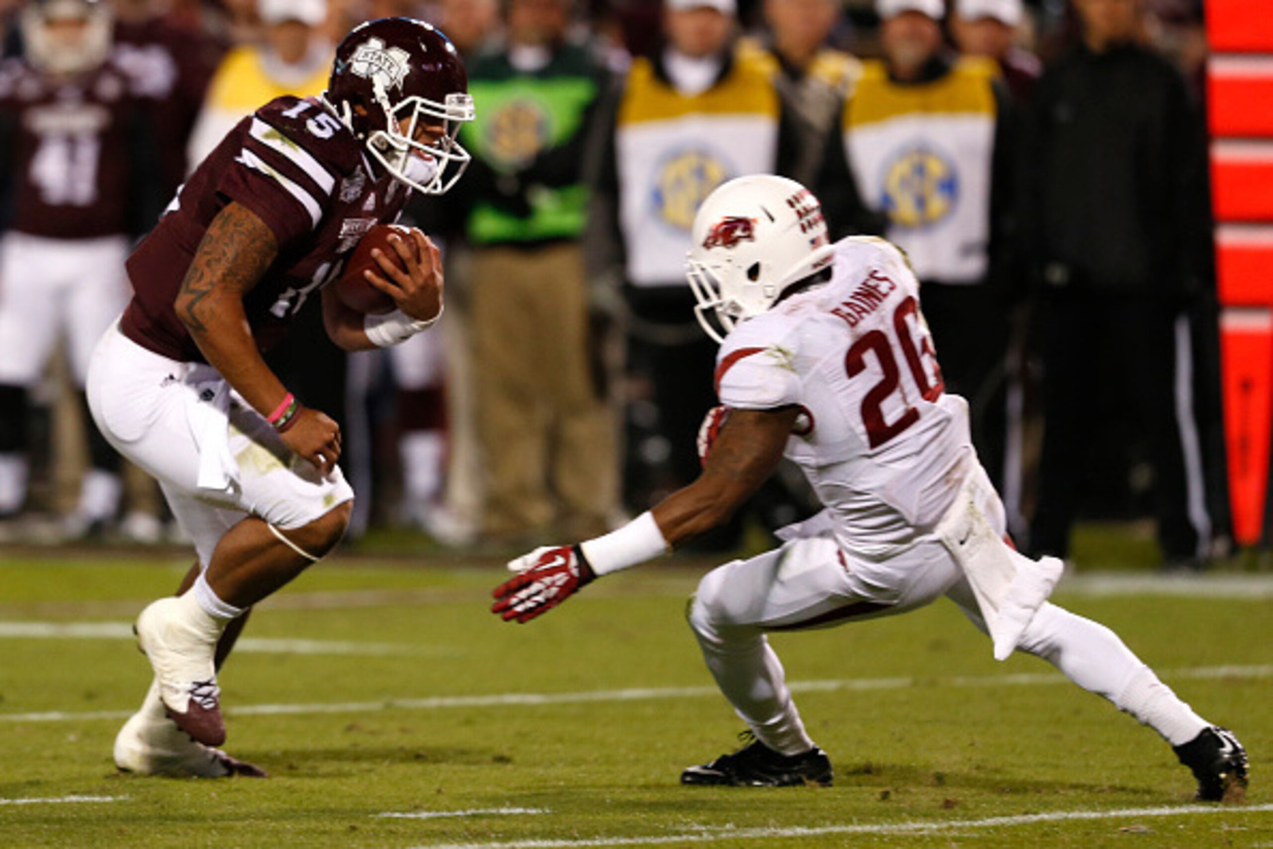 STARKVILLE, MS - NOVEMBER 1:  Dak Prescott #15 of the Mississippi State Bulldogs scrambles for a first down as he tries to get around De'Andre Coley #20 of the Arkansas Razorbacks in the first half at Davis Wade Stadium on November 1, 2014, in Starkville,