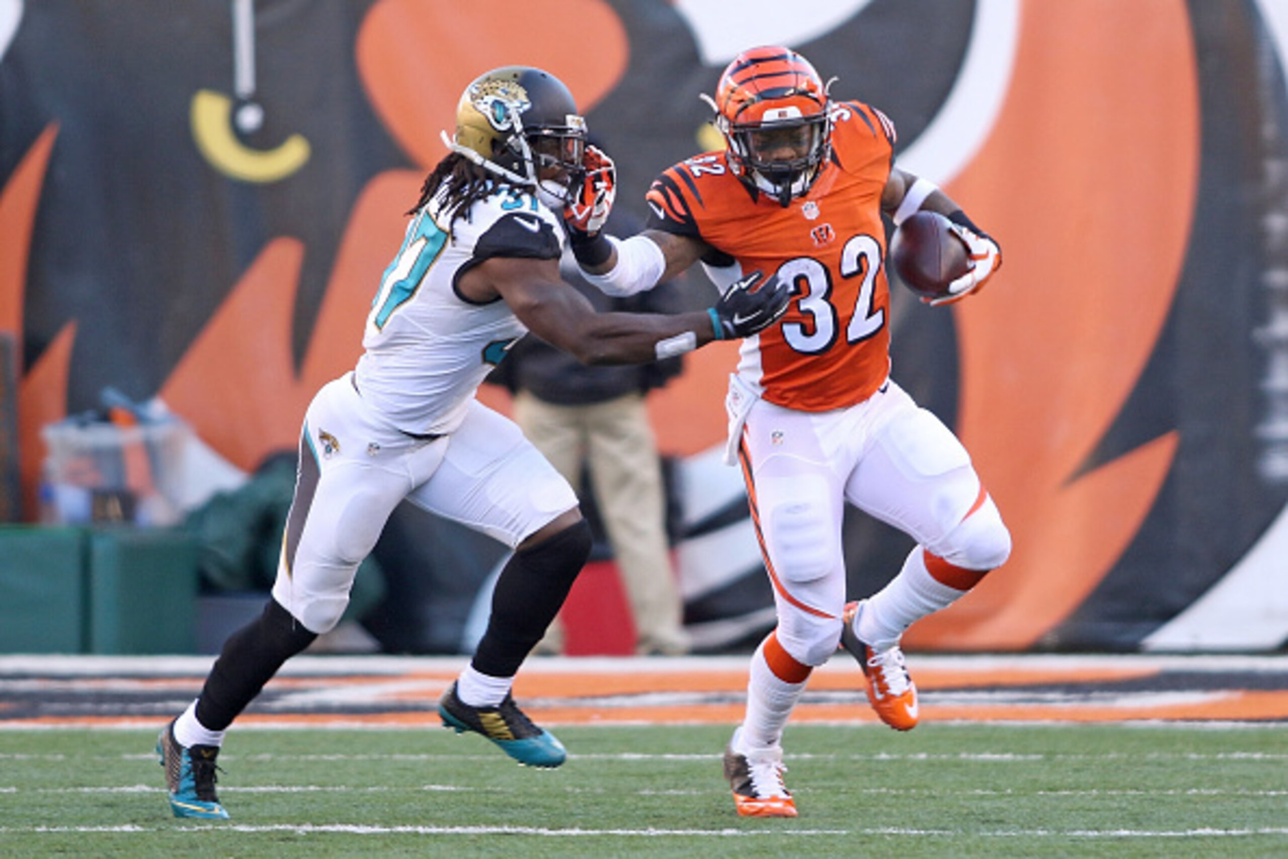 CINCINNATI, OH - NOVEMBER 2: Jeremy Hill #32 of the Cincinnati Bengals stiff arms Tommie Campbell #37 of the Jacksonville Jaguars during the third quarter at Paul Brown Stadium on November 2, 2014 in Cincinnati, Ohio. (Photo by John Grieshop/Getty Images)