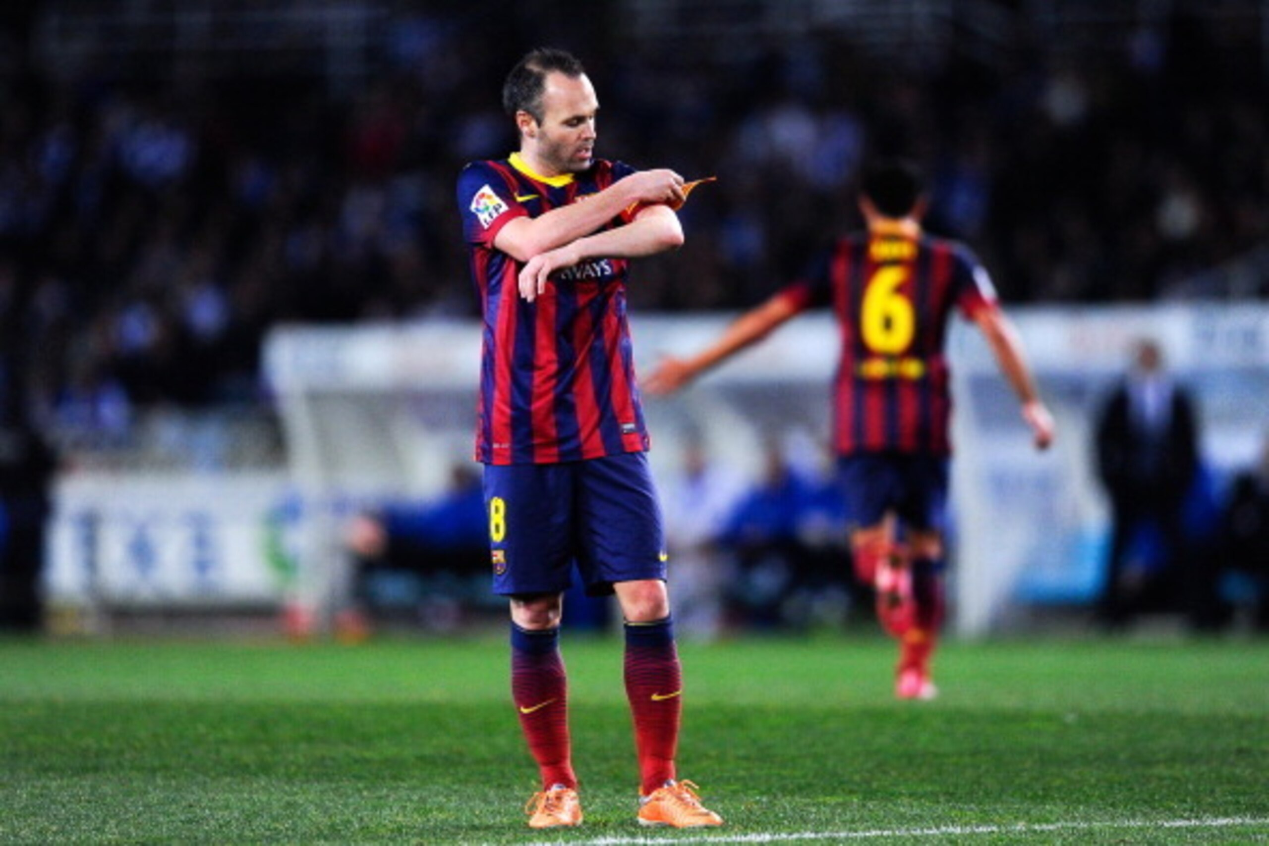 SAN SEBASTIAN, SPAIN - FEBRUARY 12: Andres Iniesta of FC Barcelona adjusts the Captain armband as his teammate Xavi Hernandez of FC Barcelona leaves the pitch during the Copa del Rey Semi Final second leg match between Real Sociedad and FC Barcelona at A SAN SEBASTIAN, SPAIN - FEBRUARY 12: Andres Iniesta of FC Barcelona adjusts the Captain armband as his teammate Xavi Hernandez of FC Barcelona leaves the pitch during the Copa del Rey Semi Final second leg match between Real Sociedad and FC Barcelona at A