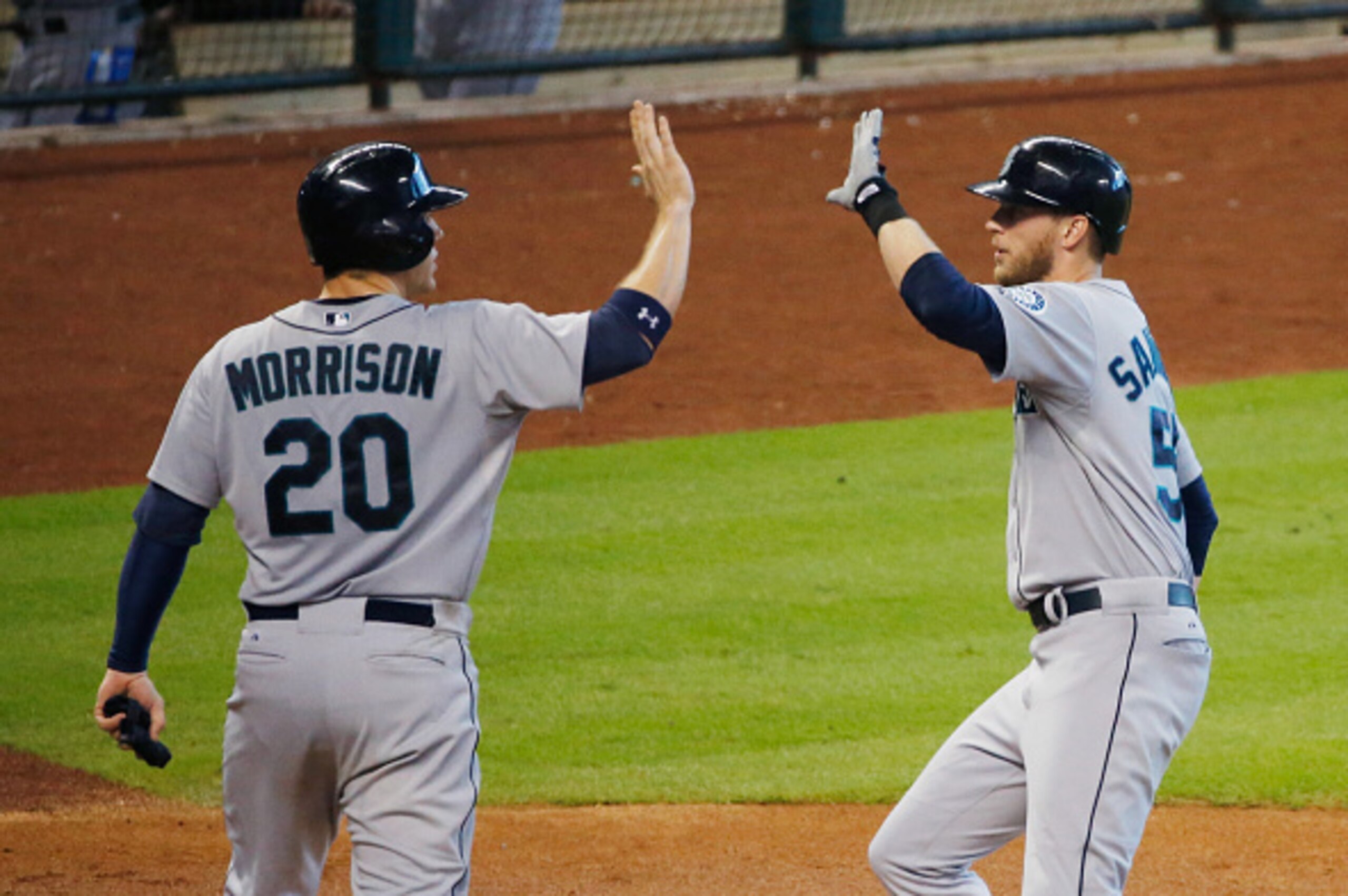 HOUSTON, TX - SEPTEMBER 21:  Logan Morrison #20 of the Seattle Mariners greets Michael Saunders #55 after Saunders scored a run in the third inning against the Houston Astros during their game at Minute Maid Park on September 21, 2014 in Houston, Texas.