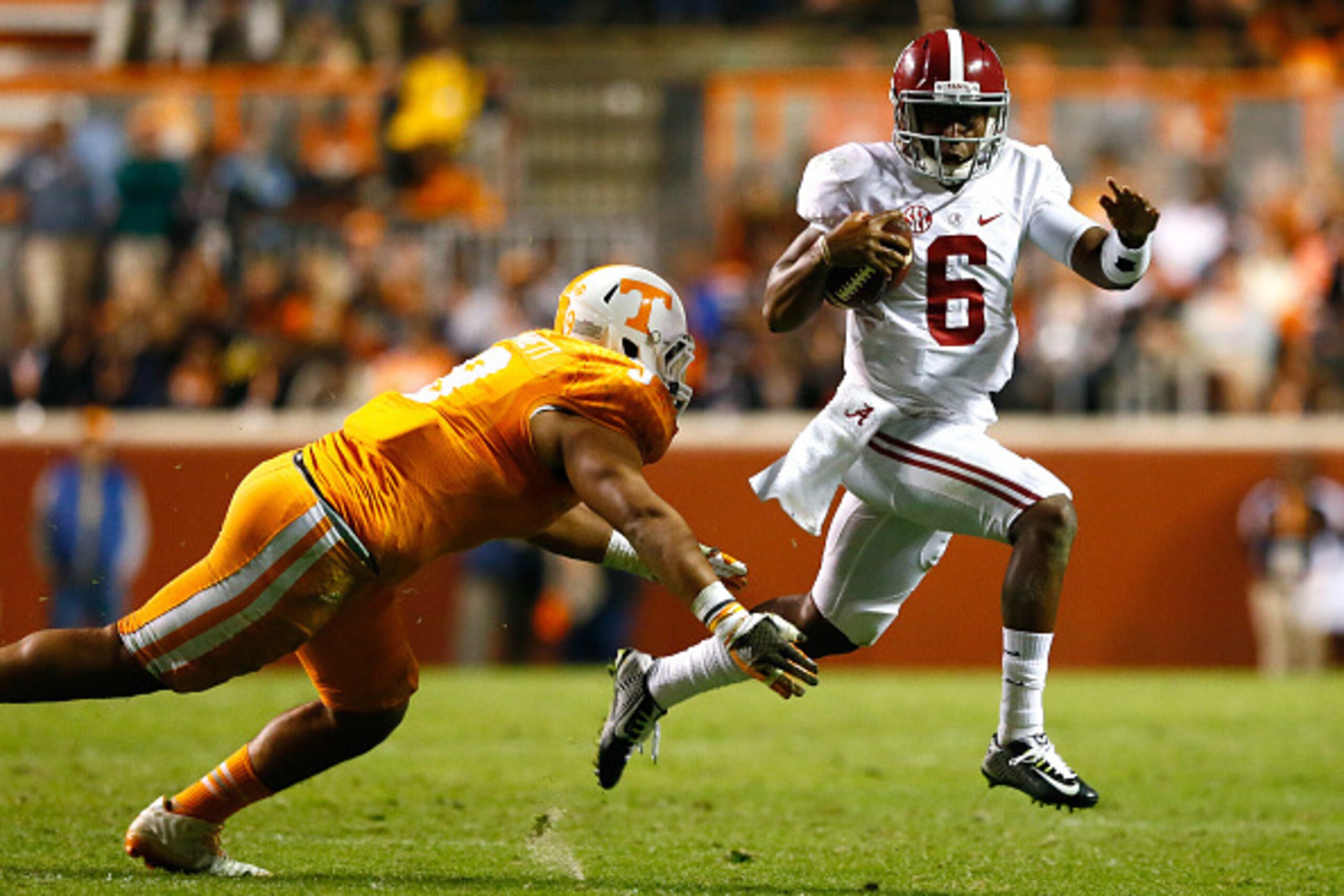 KNOXVILLE, TN - OCTOBER 25:  Blake Sims #6 of the Alabama Crimson Tide rushes away from Derek Barnett #9 of the Tennessee Volunteers at Neyland Stadium on October 25, 2014 in Knoxville, Tennessee.  (Photo by Kevin C. Cox/Getty Images)