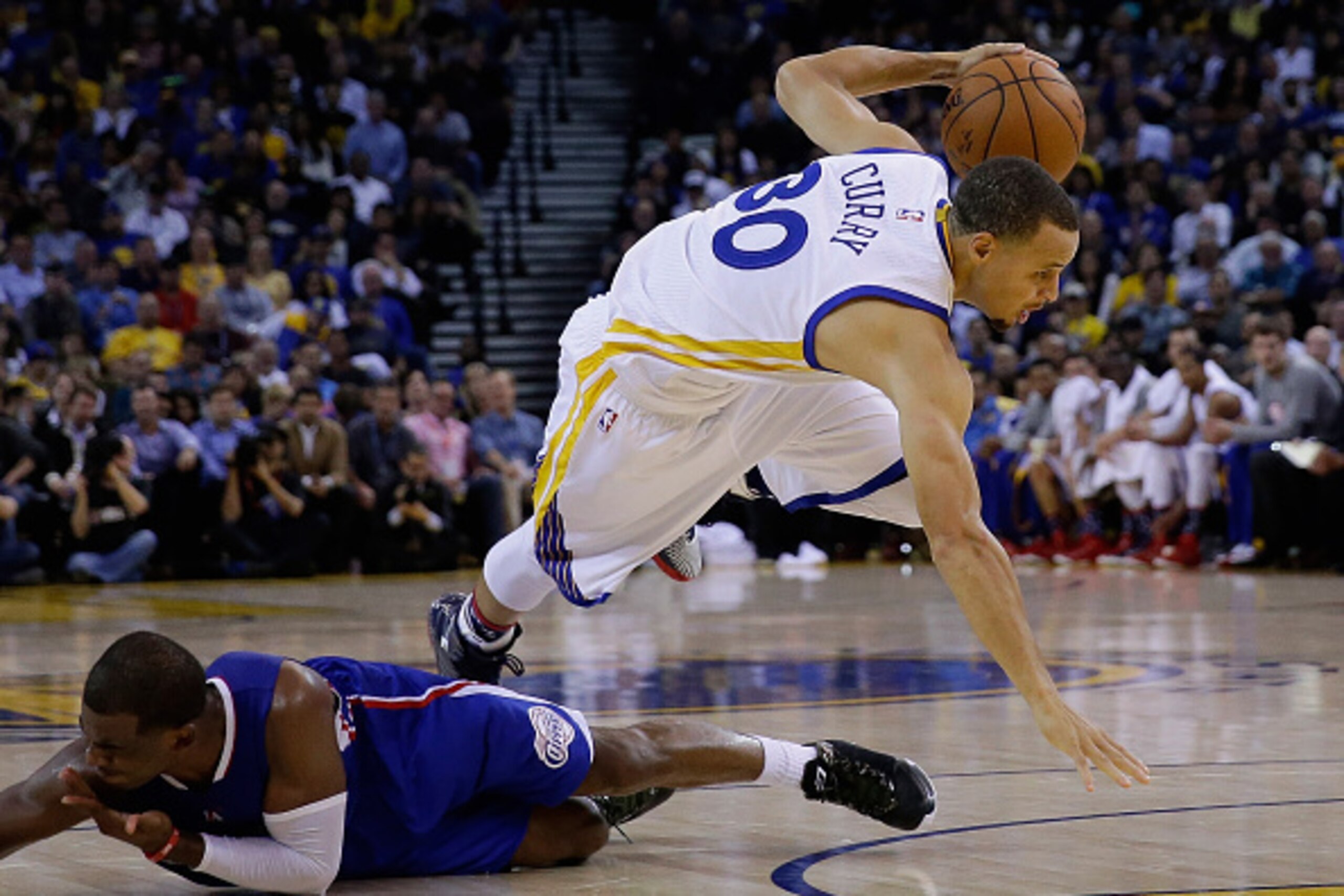 OAKLAND, CA - NOVEMBER 05:  Stephen Curry #30 of the Golden State Warriors trips over Chris Paul #3 of the Los Angeles Clippers as Paul was called for a foul at ORACLE Arena on November 5, 2014 in Oakland, California. NOTE TO USER: User expressly acknowle