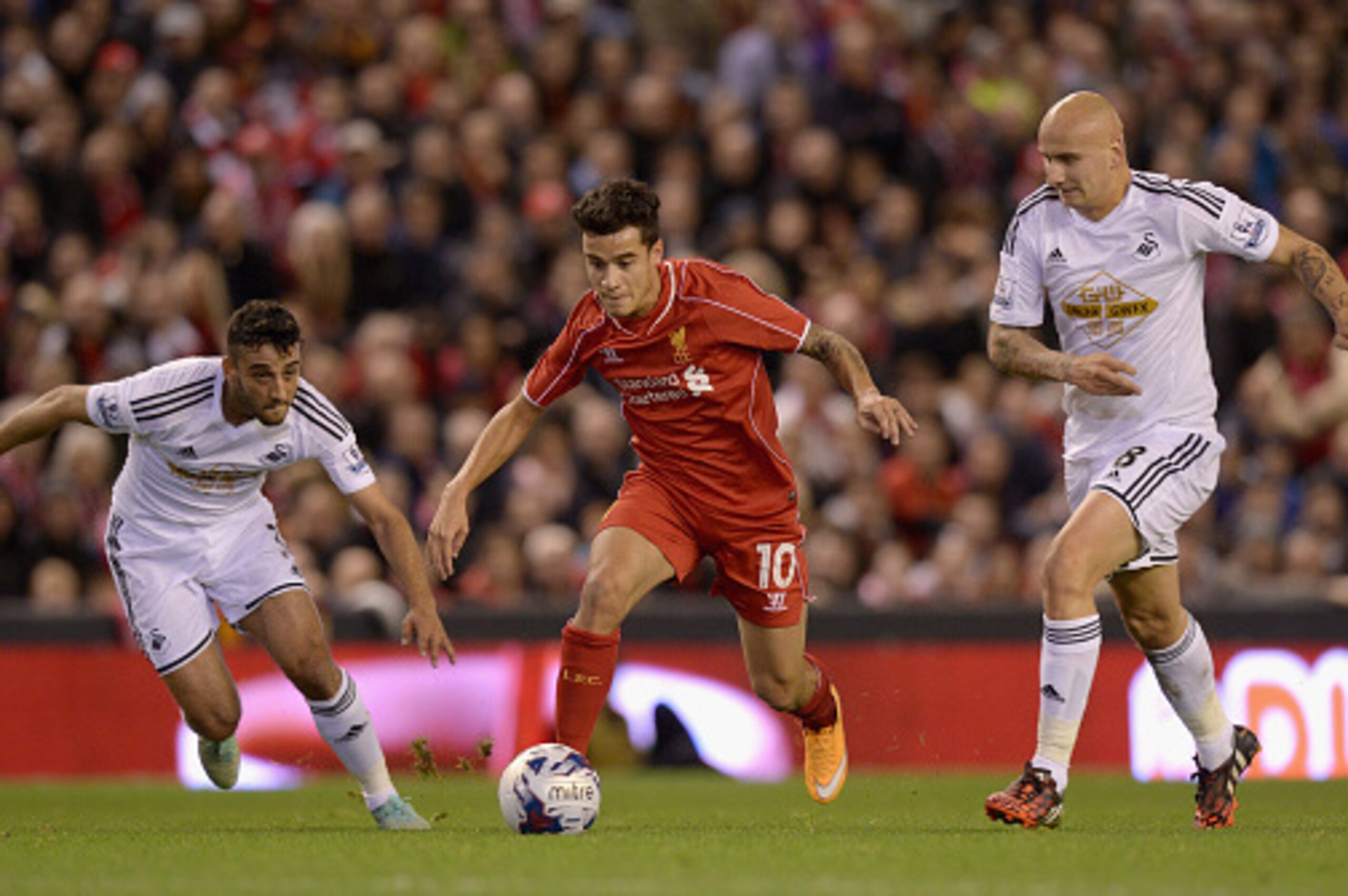 LIVERPOOL, ENGLAND - OCTOBER 28:  Philippe Coutinho of Liverpool is tackled by Neil Taylor and Jonjo Shelvey of Swansea during the Capital One Cup Fourth Round match between Liverpool and Swansea City at Anfield on October 28, 2014 in Liverpool, England. 