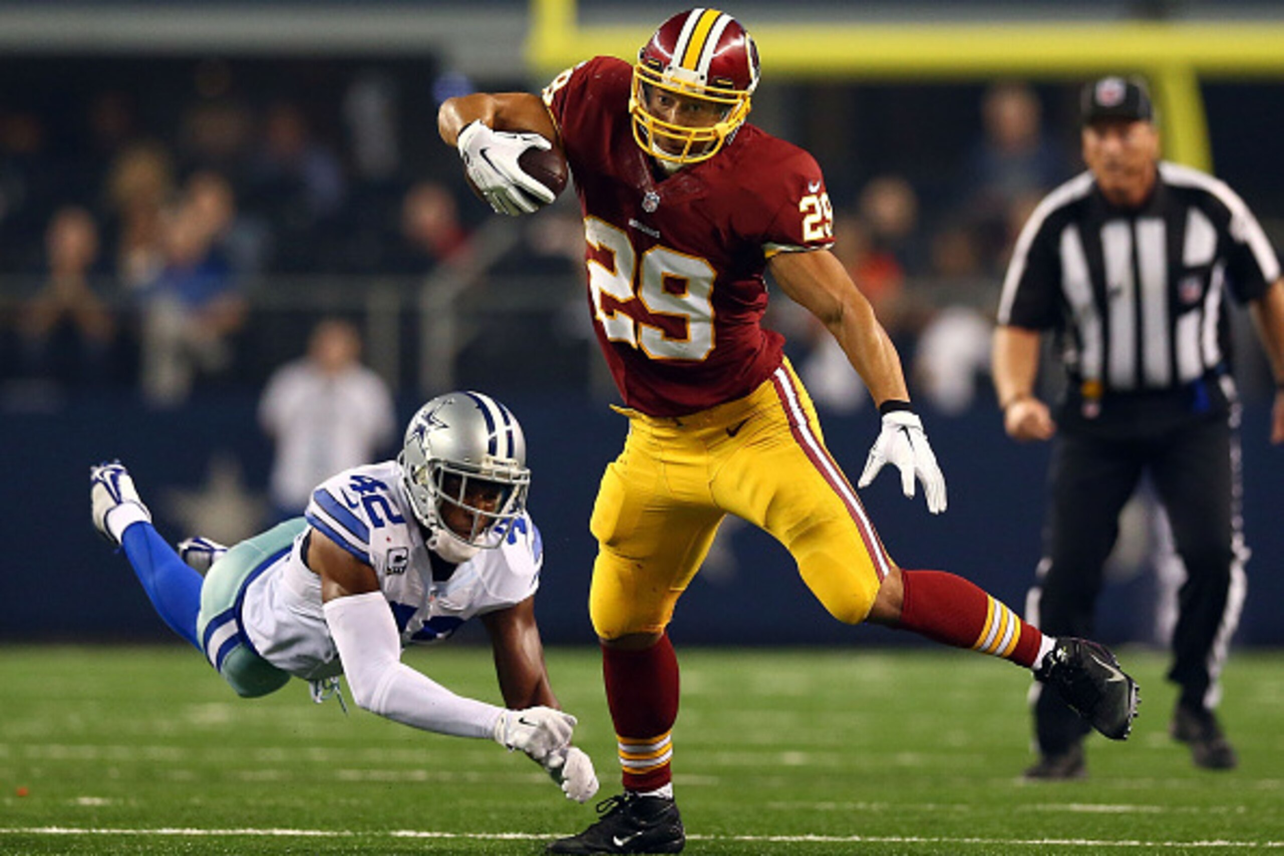 ARLINGTON, TX - OCTOBER 27:  Barry Church #42 of the Dallas Cowboys is unable to make the tackle on Roy Helu #29 of the Washington Redskins during the second half at AT&T Stadium on October 27, 2014 in Arlington, Texas.  (Photo by Ronald Martinez/Getty Im