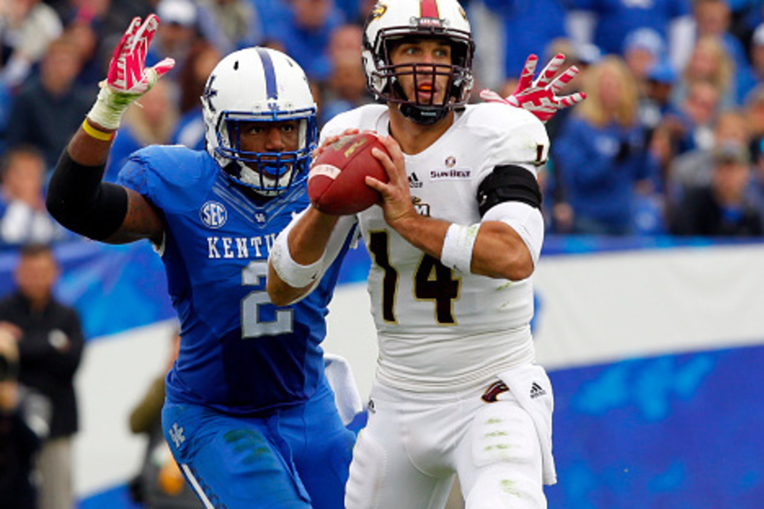 LEXINGTON, KY - OCTOBER 11: Quarterback Peter Thomas #14 of the Louisiana Monroe Warhawks throws under pressure from the Alvin Dupree #2 of the Kentucky Wildcats during the first half of play at Commonwealth Stadium on October 11, 2014 in Lexington, Kentu
