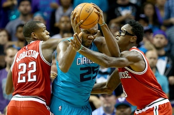 CHARLOTTE, NC - OCTOBER 29:  Teammates Khris Middleton #22 and Larry Sanders #8 of the Milwaukee Bucks try to stop Al Jefferson #25 of the Charlotte Hornets during their game at Time Warner Cable Arena on October 29, 2014 in Charlotte, North Carolina.  Th