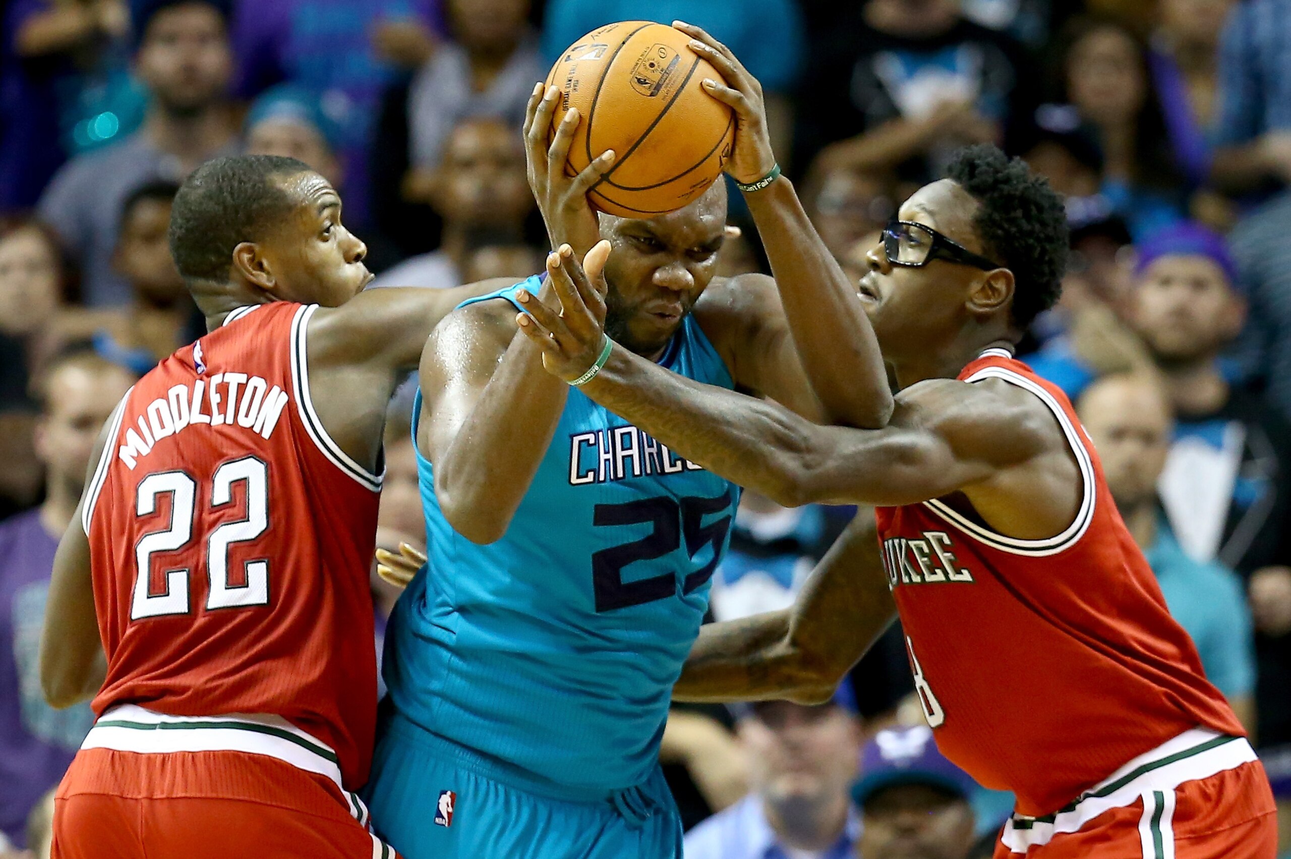 CHARLOTTE, NC - OCTOBER 29:  Teammates Khris Middleton #22 and Larry Sanders #8 of the Milwaukee Bucks try to stop Al Jefferson #25 of the Charlotte Hornets during their game at Time Warner Cable Arena on October 29, 2014 in Charlotte, North Carolina.  Th