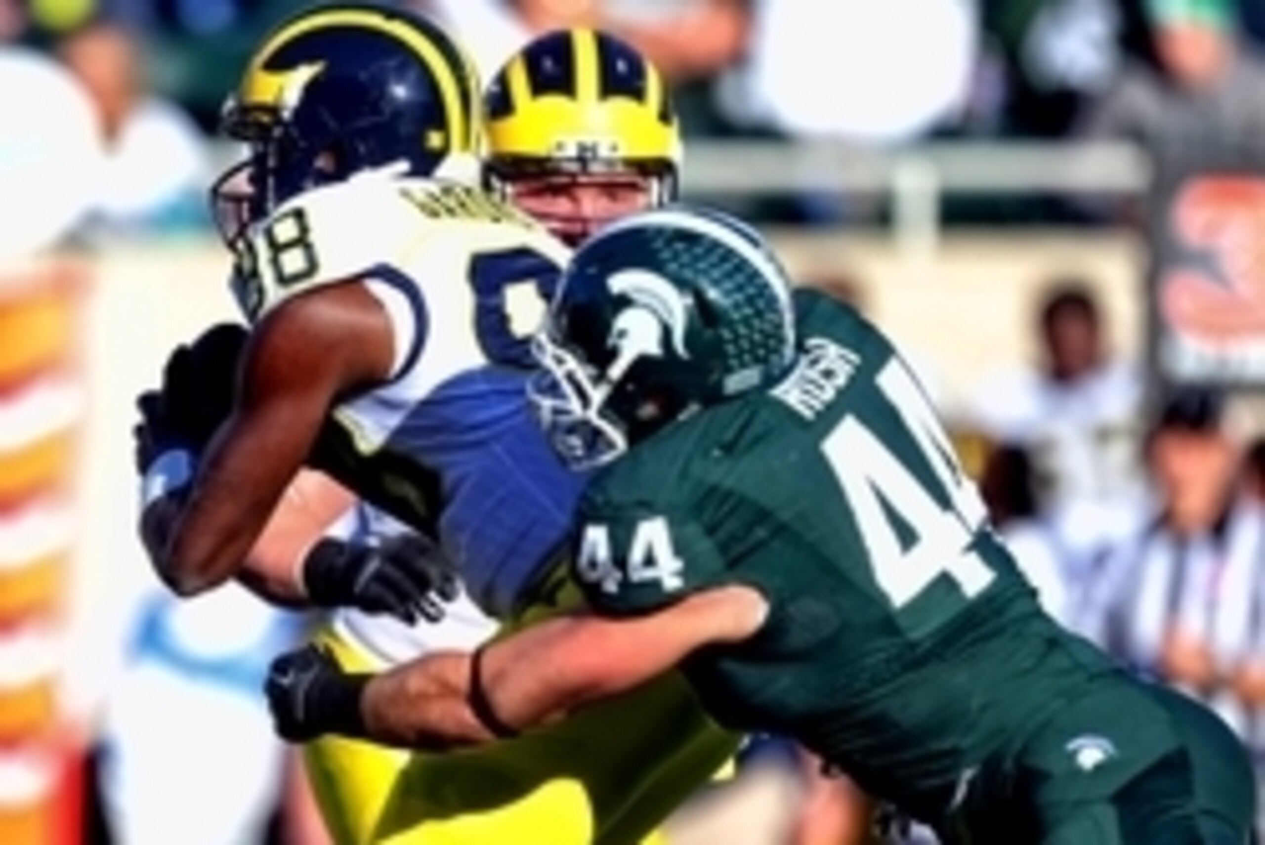 Oct 25, 2014; East Lansing, MI, USA; Michigan Wolverines quarterback Devin Gardner (98) is sacked by Michigan State Spartans defensive end Marcus Rush (44) during the first half of a game at Spartan Stadium. Mandatory Credit: Mike Carter-USA TODAY Sports