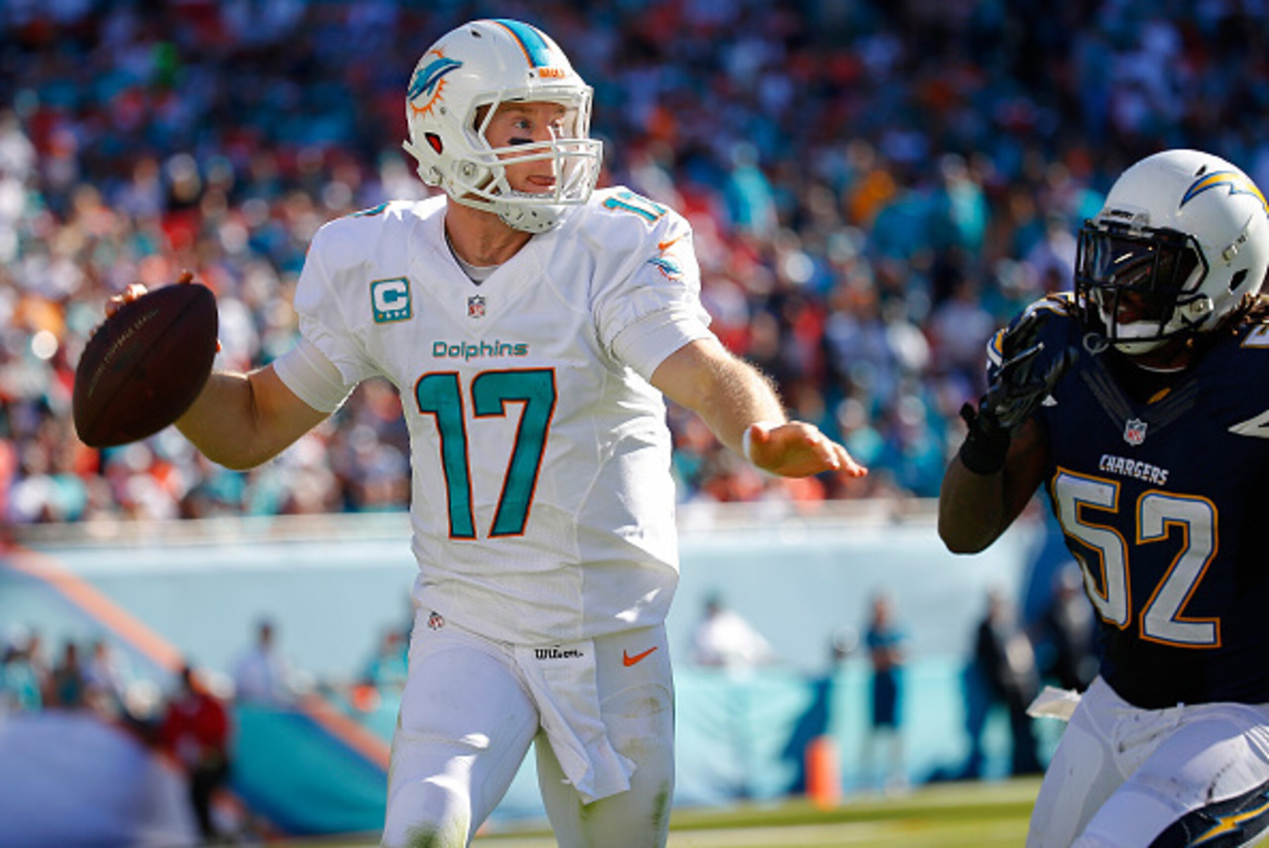MIAMI GARDENS, FL - NOVEMBER 02:  Quarterback Ryan Tannehill #17 of the Miami Dolphins scrambles as he throws under pressure from outside linebacker Reggie Walker #52 of the San Diego Chargers during a game at Sun Life Stadium on November 2, 2014 in Miami