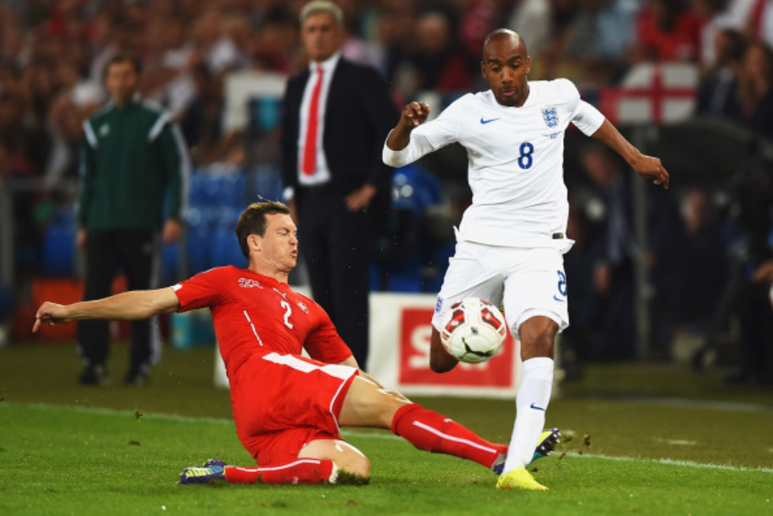 BASEL, SWITZERLAND - SEPTEMBER 08:  Fabian Delph of England is tackled by Stephan Lichtsteiner of Switzerland during the UEFA EURO 2016 Group E qualifying match between Switzerland and England at St Jakob-Park on September 8, 2014 in Basel, Switzerland.  