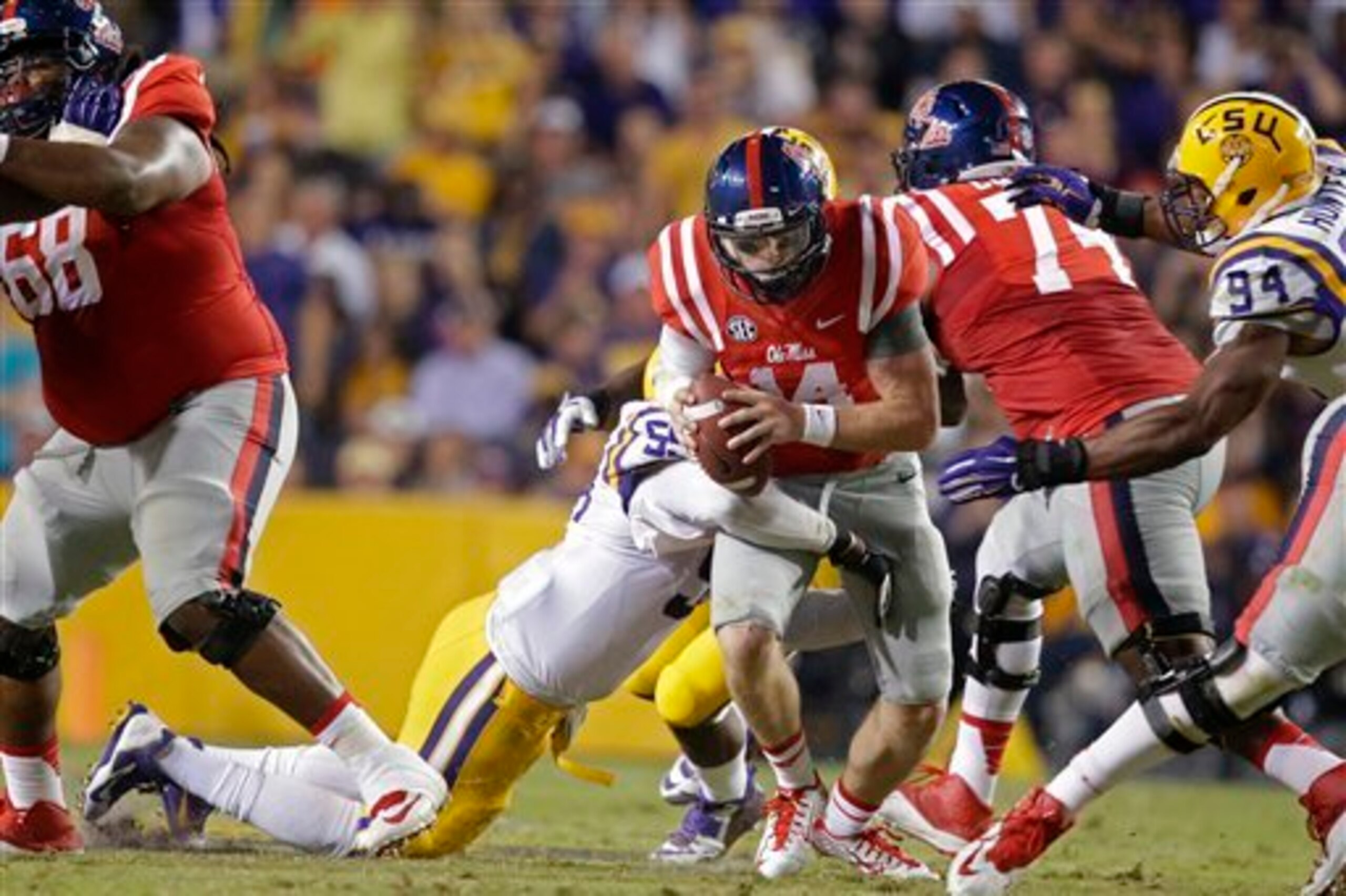 Ole Miss quarterback Bo Wallace (center) gets sacked by LSU's Jermauria Rasco (No. 59) and Danielle Hunter (No. 94)