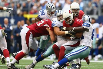 ARLINGTON, TX - NOVEMBER 02:  Larry Fitzgerald #11 of the Arizona Cardinals is tackled by  George Selvie #99 of the Dallas Cowboys in the third quarter at AT&T Stadium on November 2, 2014 in Arlington, Texas.  (Photo by Ronald Martinez/Getty Images)