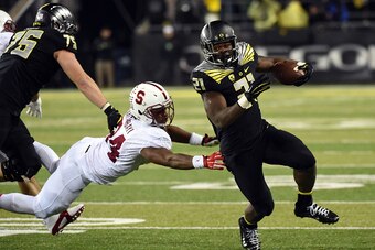 EUGENE, OR - NOVEMBER 1: Running back Royce Freeman #21 of the Oregon Ducks avoids the tackle of linebacker Peter Kalambayi #34 of the Stanford Cardinal during the fourth quarter of the game at Autzen Stadium on November 1, 2014 in Eugene, Oregon. The Duc