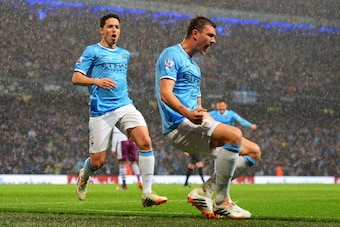 MANCHESTER, ENGLAND - MAY 07:  Edin Dzeko of Manchester City celebrates scoring the opening goal with Samir Nasri (L) during the Barclays Premier League match between Manchester City and Aston Villa at Etihad Stadium on May 7, 2014 in Manchester, England.
