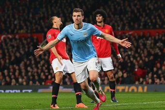 MANCHESTER, ENGLAND - MARCH 25:  Edin Dzeko of Manchester City celebrates scoring the second goal during the Barclays Premier League match between Manchester United and Manchester City at Old Trafford on March 25, 2014 in Manchester, England.  (Photo by A