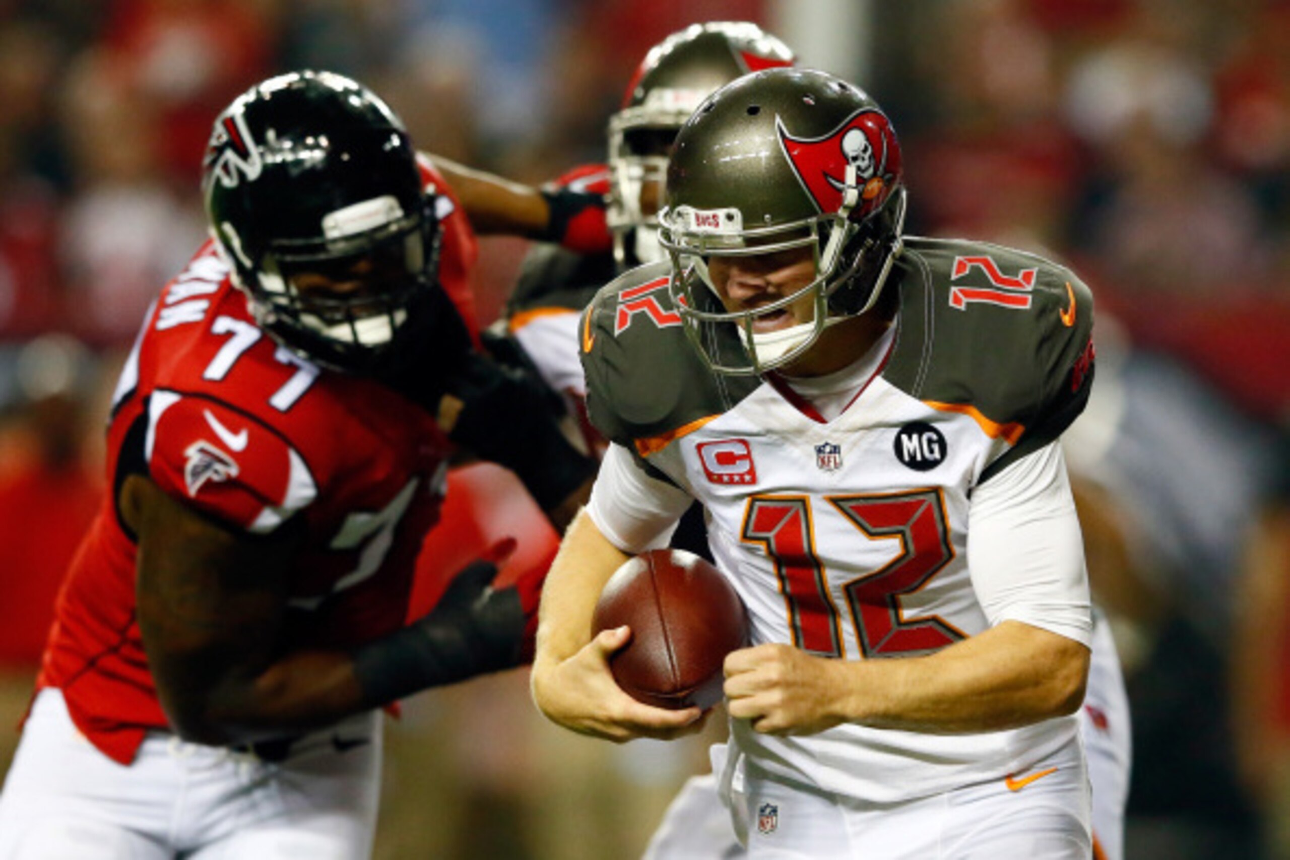 ATLANTA, GA - SEPTEMBER 18: Quarterback Josh McCown #12 of the Tampa Bay Buccaneers scrambles under pressure from defensive end Ra'Shede Hageman #77 of the Atlanta Falcons during a game at the Georgia Dome on September 18, 2014 in Atlanta, Georgia.  (Phot