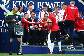 LEICESTER, ENGLAND - SEPTEMBER 21:  Angel di Maria of Manchester United shakes hands with Ryan Giggs the assisitant manager of Manchester United and Louis van Gaal the manager of Manchester United as he is substituted in the second half during the Barclay