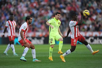 ALMERIA, SPAIN - NOVEMBER 08:   Lionel Messi of FC Barcelona chips the ball over Ramon Azziz of UD Almeria during the La Liga match between UD Almeria and FC Barcelona at estadio de los Juegos Mediterraneos on November 8, 2014 in Almeria, Spain.  (Photo b