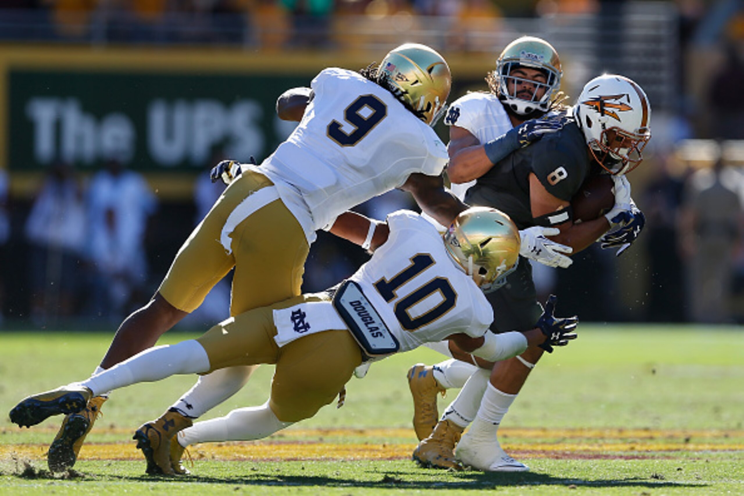 TEMPE, AZ - NOVEMBER 08:  Running back D.J. Foster #8 of the Arizona State Sun Devils is tackled by linebacker Jaylon Smith #9 and safety Max Redfield #10 of the Notre Dame Fighting Irish as he rushes the football during the second quarter of the college 