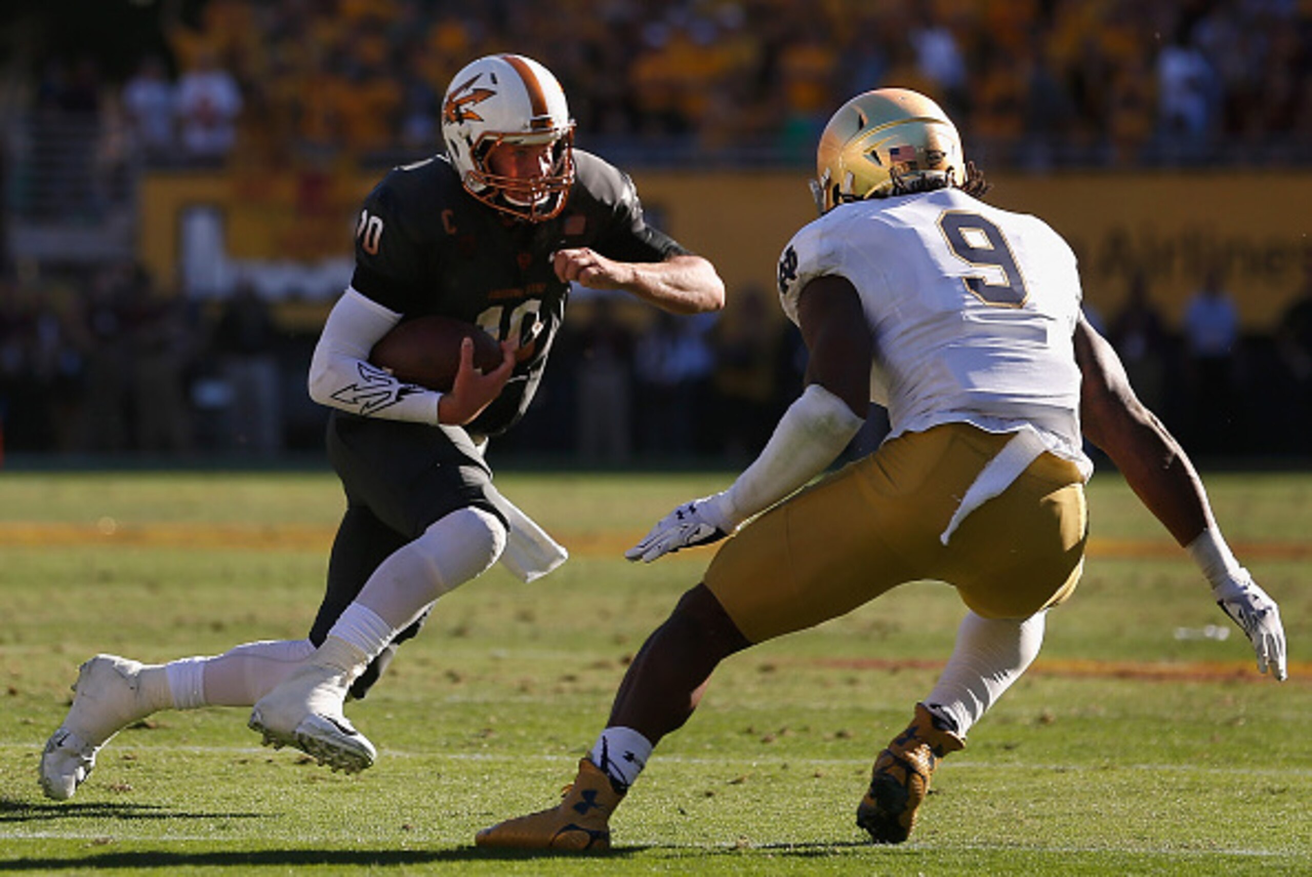 TEMPE, AZ - NOVEMBER 08:  Quarterback Taylor Kelly #10 of the Arizona State Sun Devils rushes the football against linebacker Jaylon Smith #9 of the Notre Dame Fighting Irish during the college football game at Sun Devil Stadium on November 8, 2014 in Tem