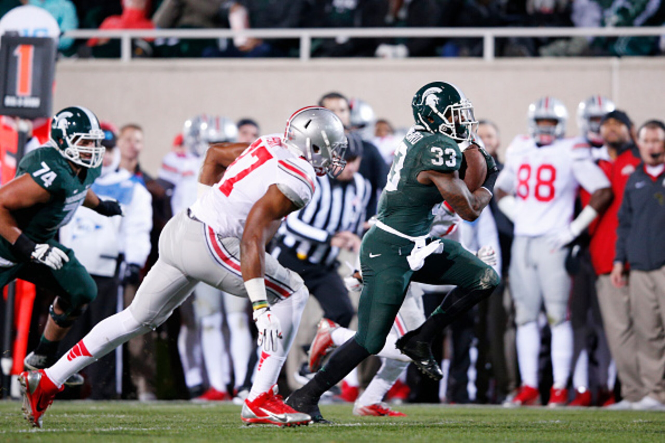 EAST LANSING, MI - NOVEMBER 8: Jeremy Langford #33 of the Michigan State Spartans runs for a 33-yard touchdown in the first quarter of the game against the Ohio State Buckeyes at Spartan Stadium on November 8, 2014 in East Lansing, Michigan. (Photo by Joe